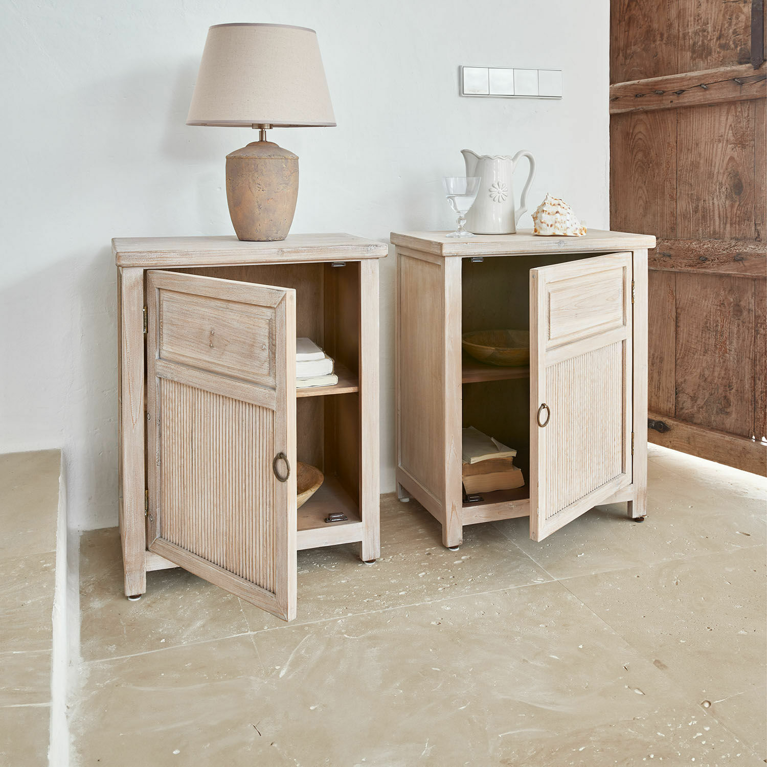 Nachttisch 2er Set Brolive Zwei helle Holzschränke mit offenen Türen und Lampe darauf im rustikalen Stil