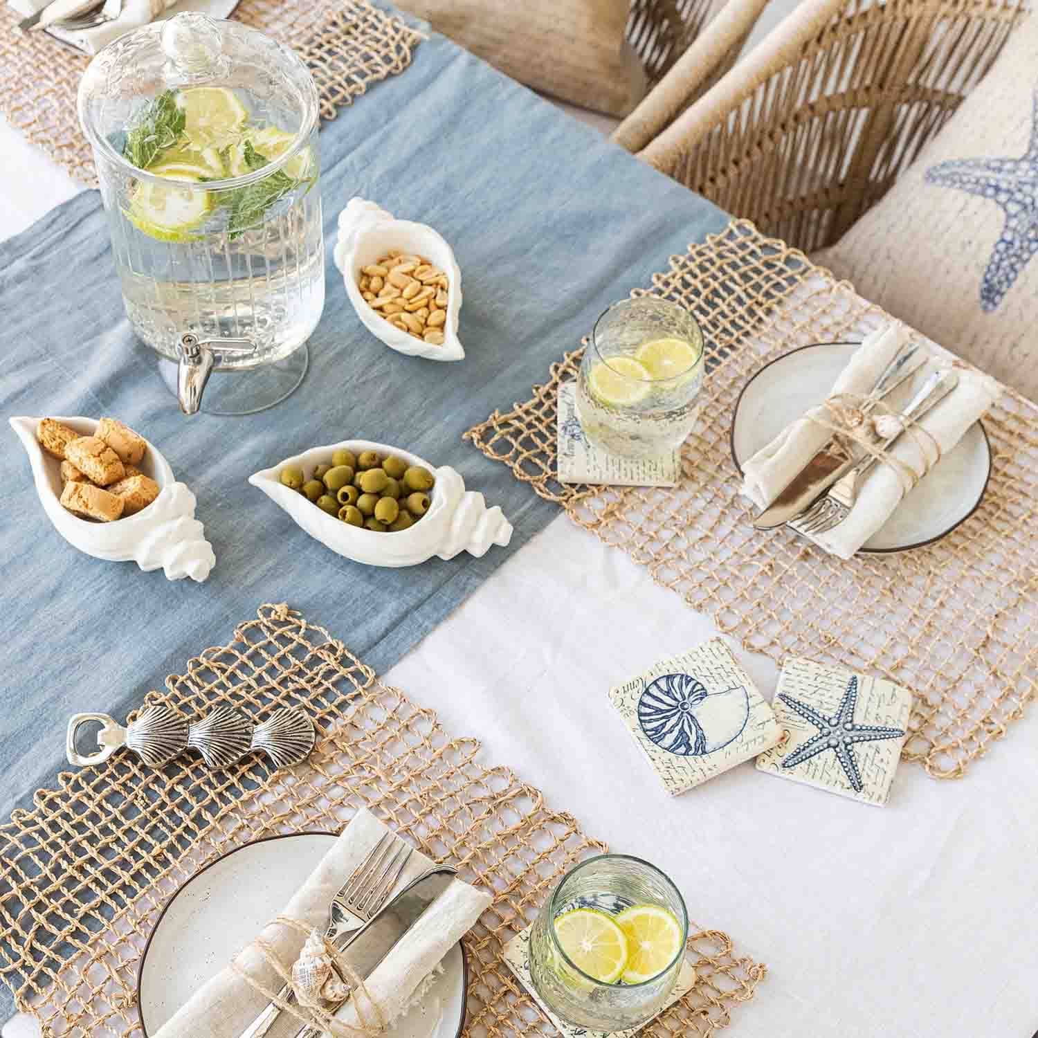 Sommerlicher Tisch mit maritimer Dekoration, weiße Muschel-Schalen aus Keramik mit Snacks und Limonade