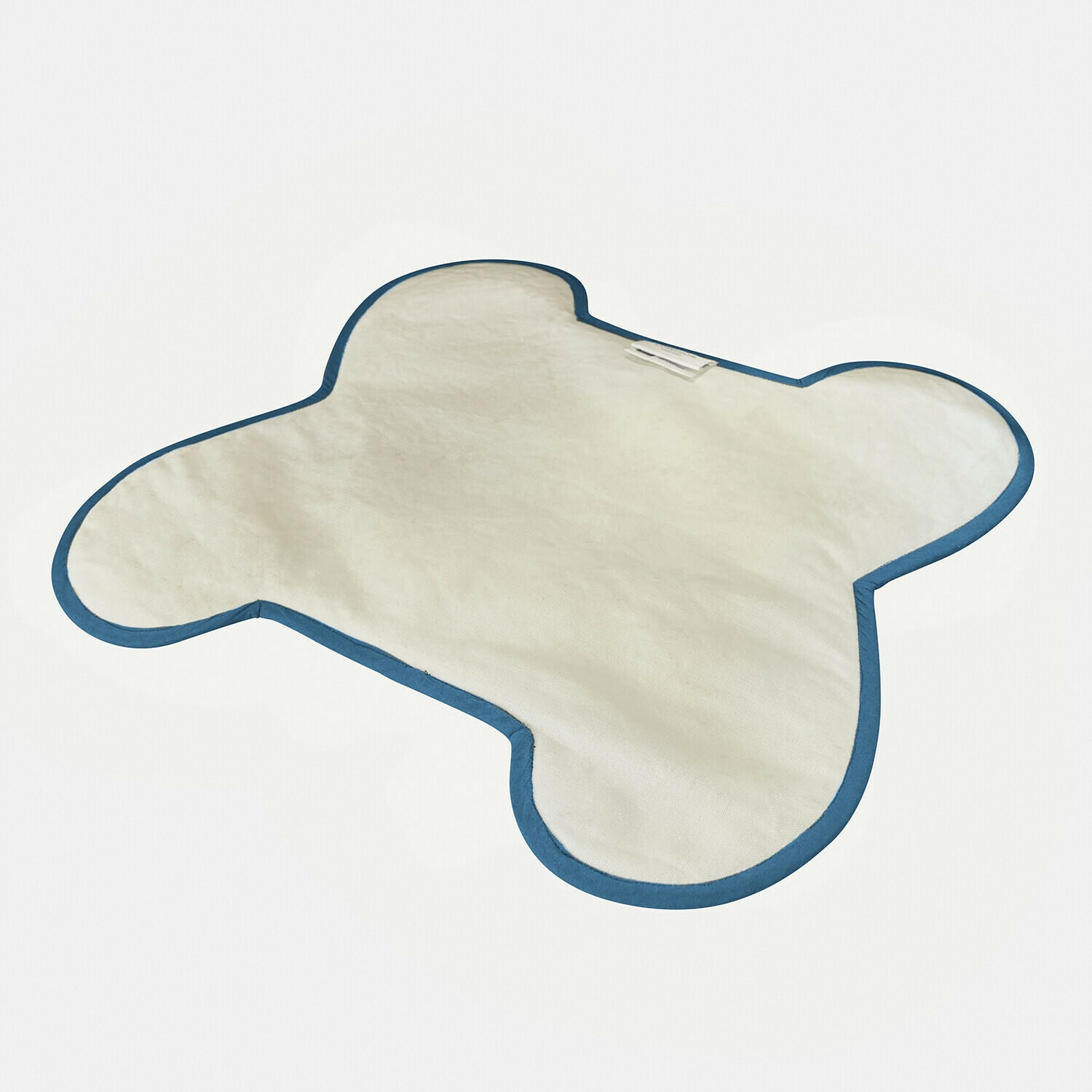 Weiche Matte in Bärenform aus weißem Stoff mit blauer Umrandung, ideal fürs Kinderzimmer