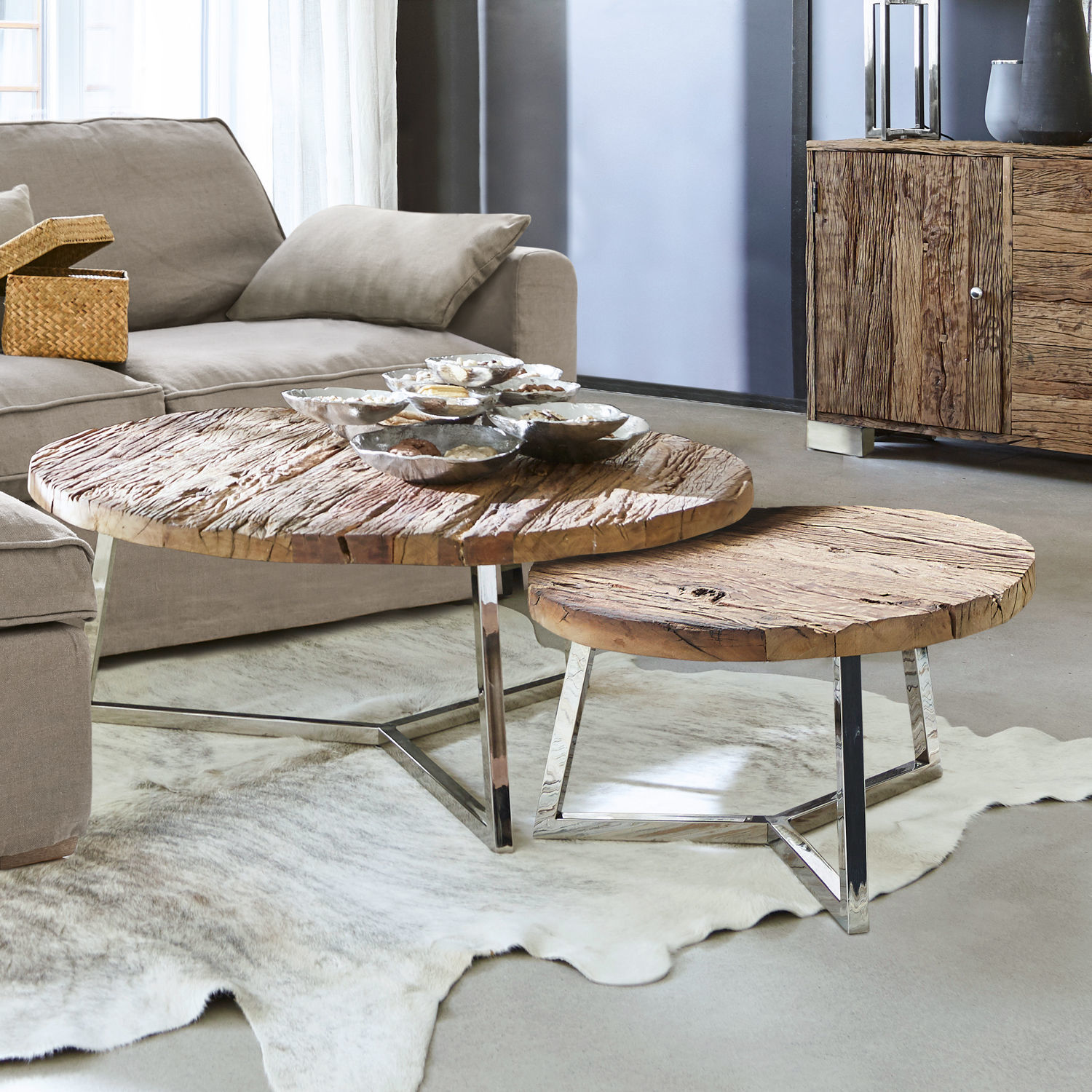 Zwei runde Couchtische mit Holzplatte und Metallbeinen in modernem Wohnzimmer