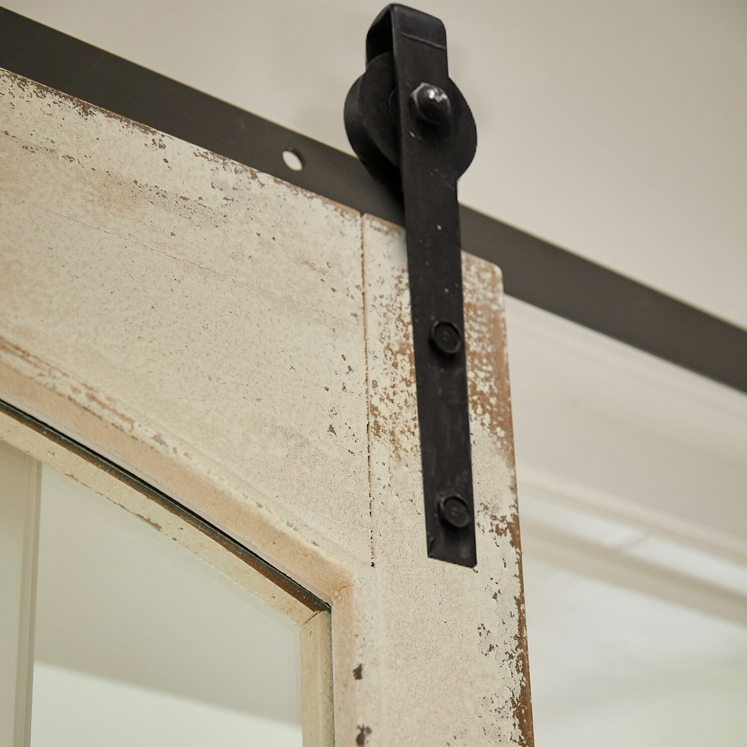Nahaufnahme einer beige patinierten Tür mit schwarzem Metallbeschlag für Schiebetür
