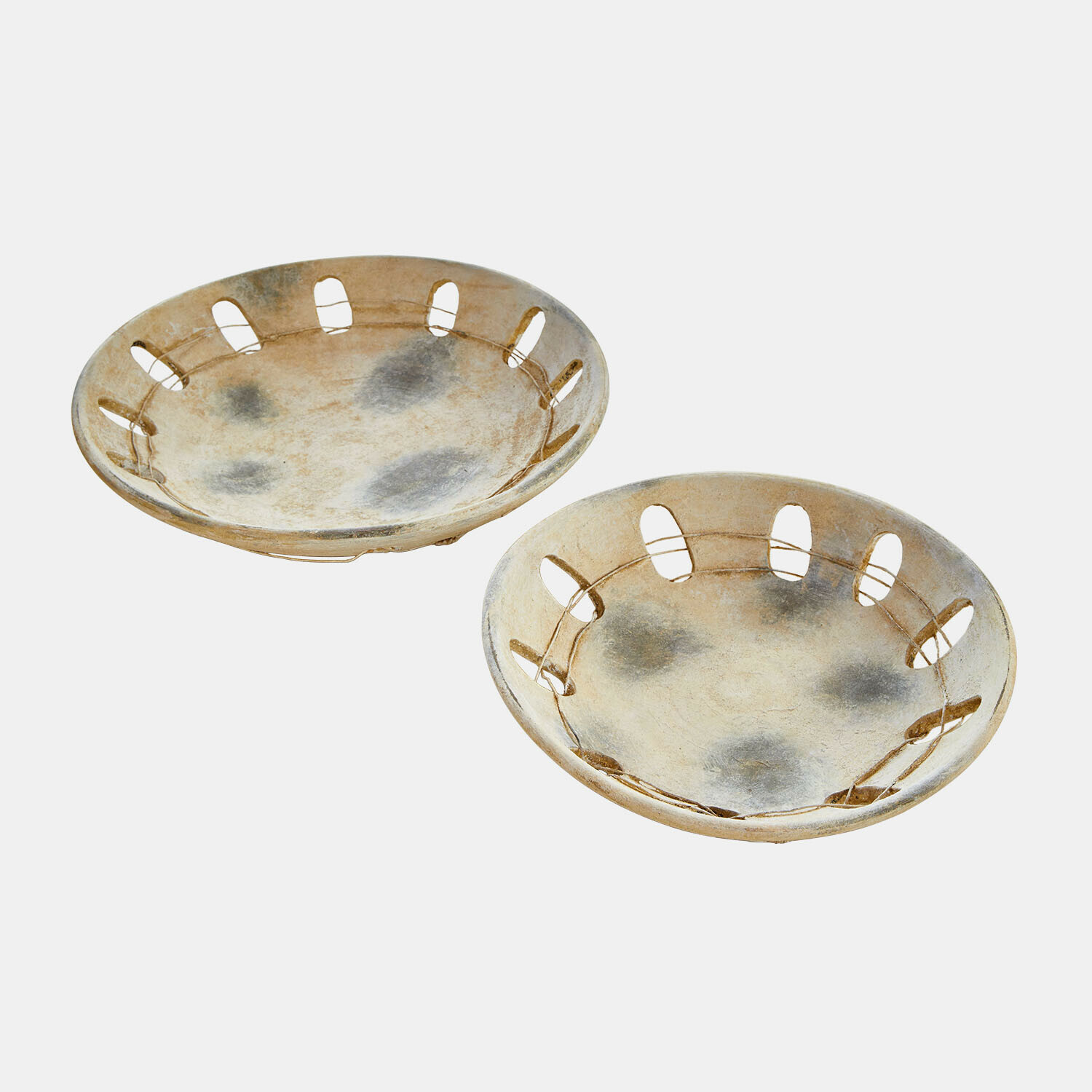 Zwei runde Keramikteller in Beige mit Öffnungen am Rand, rustikales Design