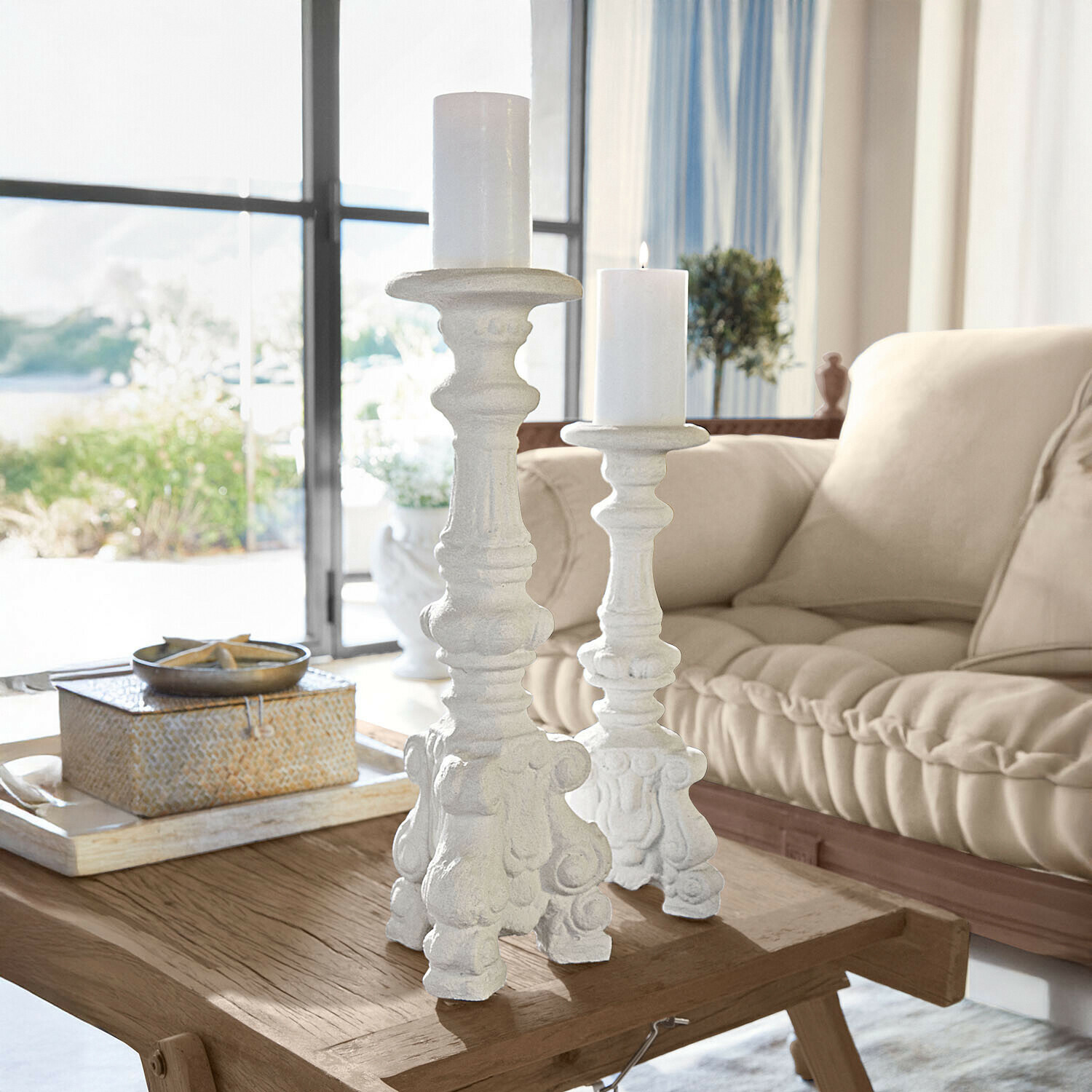 Kerzenständer 2er Set Chaverny Zwei weiße, verzierte Kerzenhalter aus Holz auf einem Holztisch in hellem Wohnzimmer mit beigem Sofa