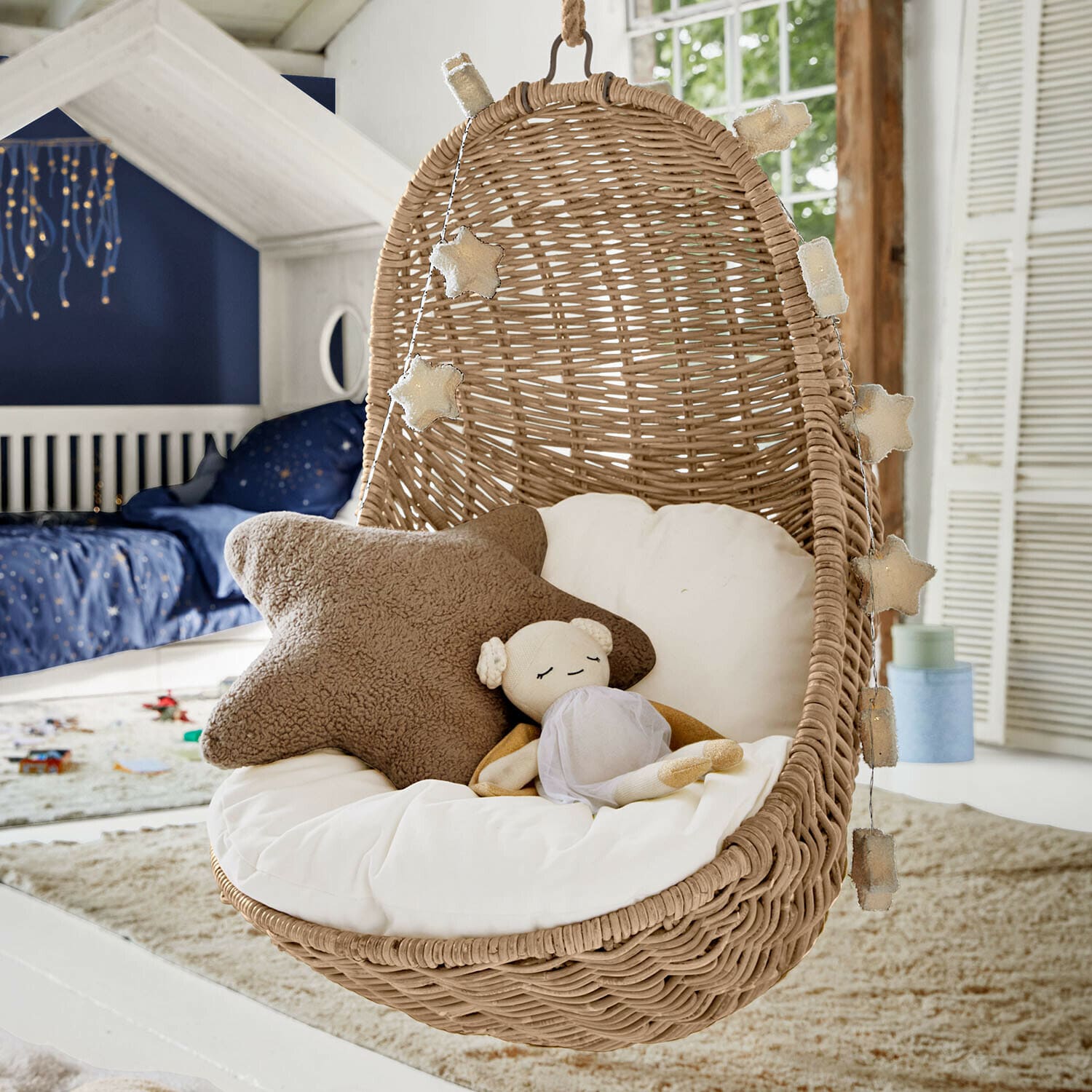 Kinderhängesessel Twinkla Hängesessel aus Rattan mit weißem Kissen und Stern-Lichterkette im Kinderzimmer