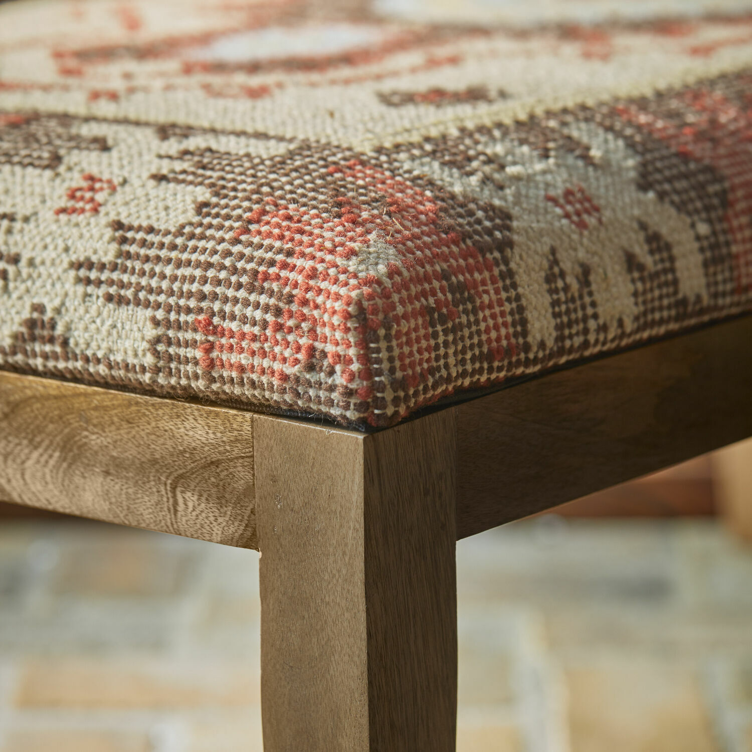 Holzstuhlbein mit gepolstertem Sitzbezug in geometrischem Muster in Beige, Braun und Rot