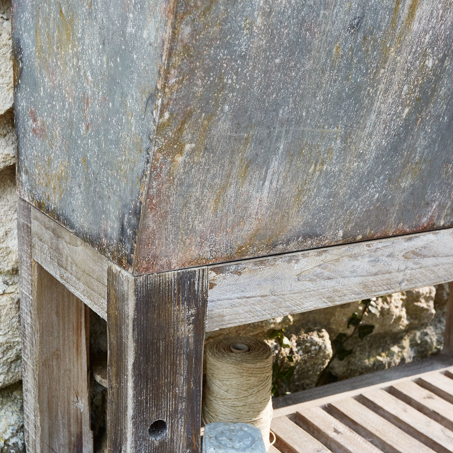 Rustikale Gartenbank aus gealtertem Holz mit patiniertem Metallbehälter, vintage Stil