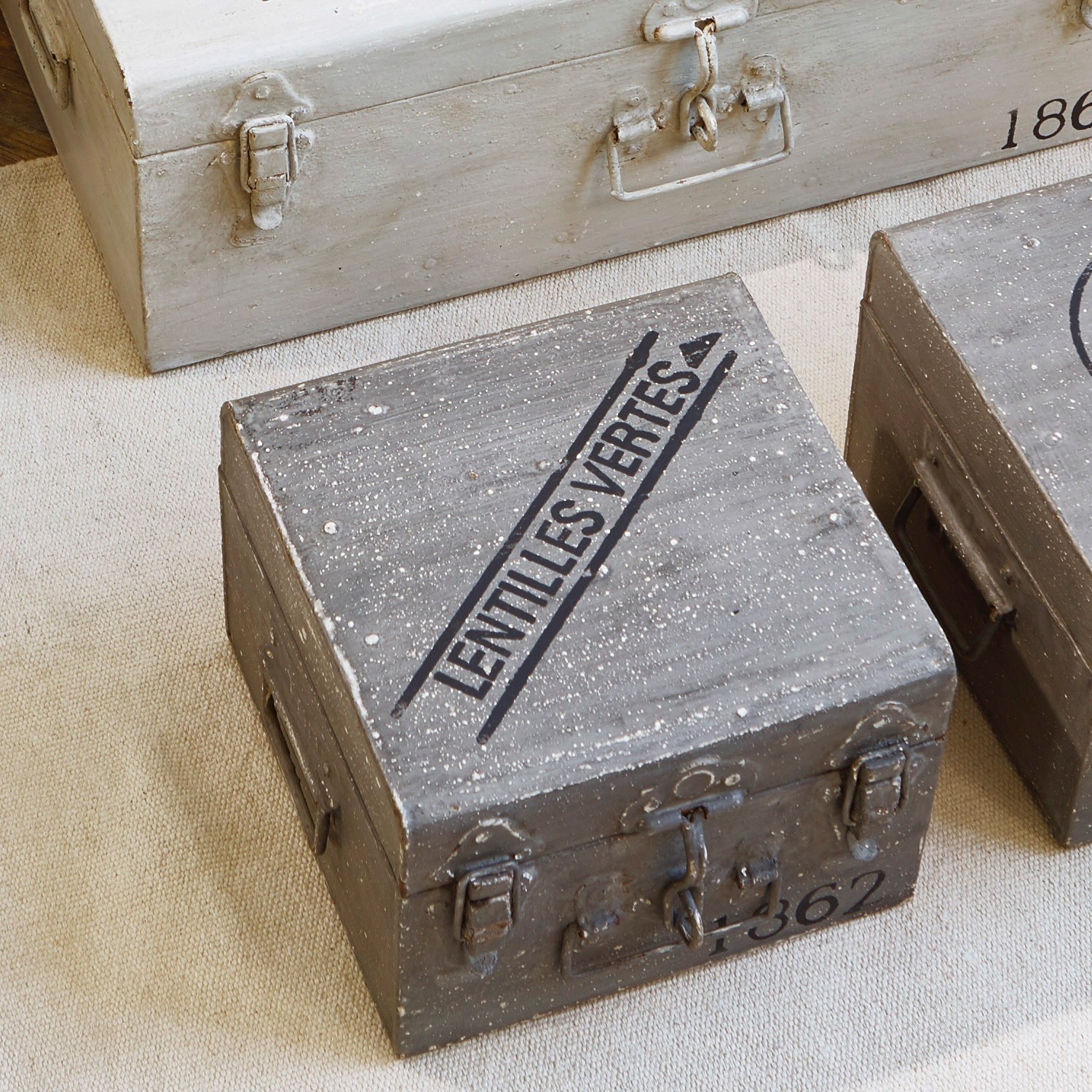 Graue Metallschachtel mit Aufschrift Lentilles Vertes auf beigem Teppich, dekorative Vintage-Box
