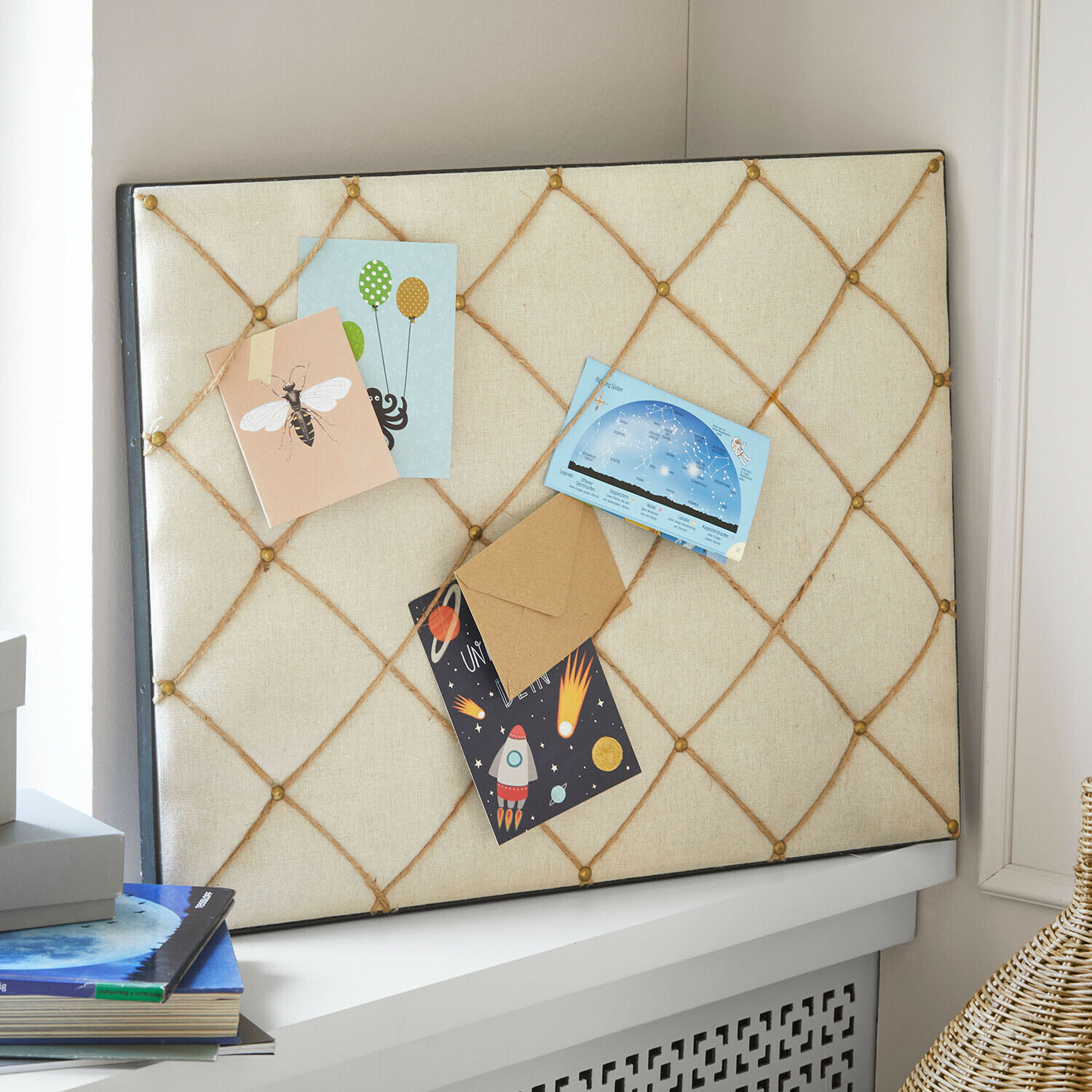 Memoboard mit beigem Stoff und Schnüren zum Befestigen von Notizen und Karten im Zimmer