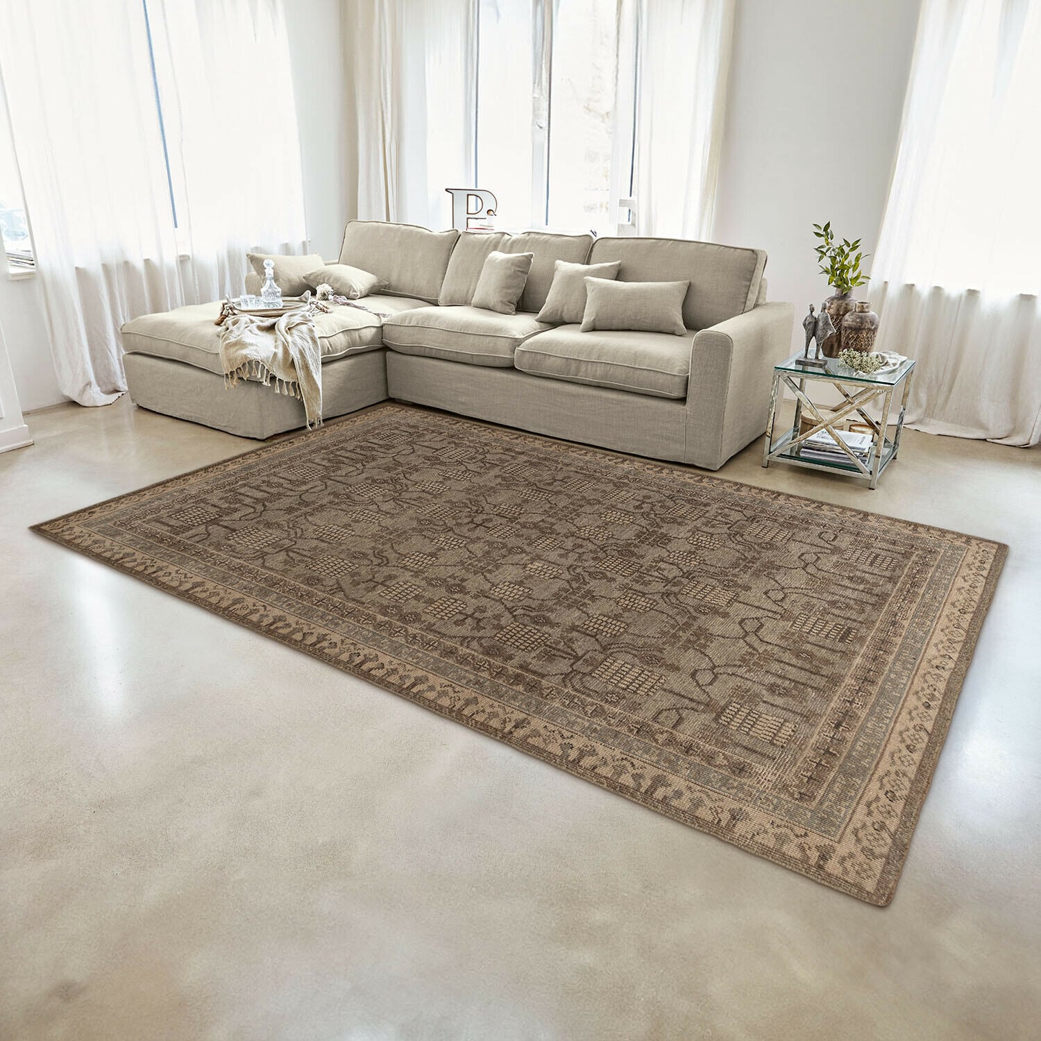Teppich Hélavor Brauner Teppich mit orientalischem Muster auf hellem Boden in modernem Wohnzimmer mit beigem Sofa