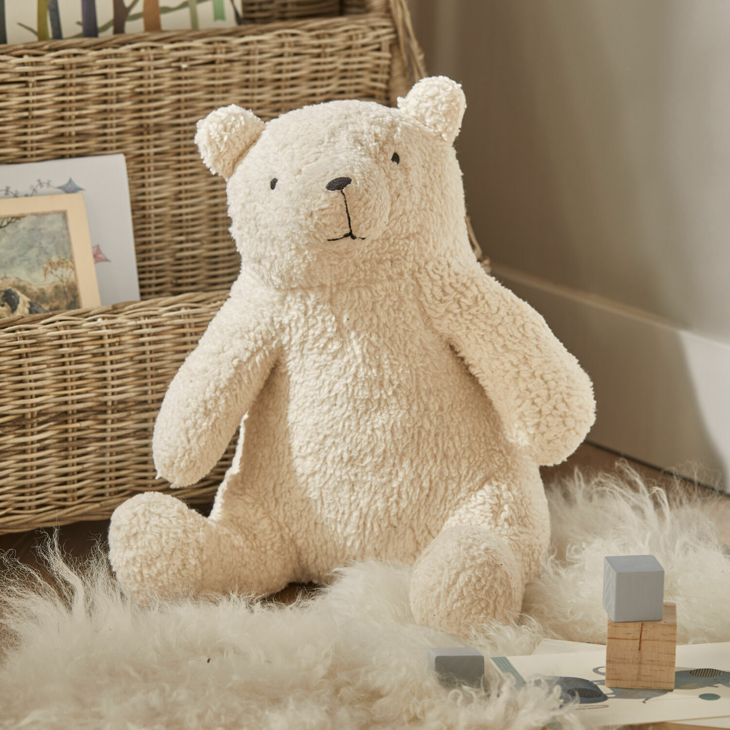 Stofftier Hugo Weicher Plüschbär in Creme auf Teppich aus Naturmaterialien, Kinderzimmerdekoration
