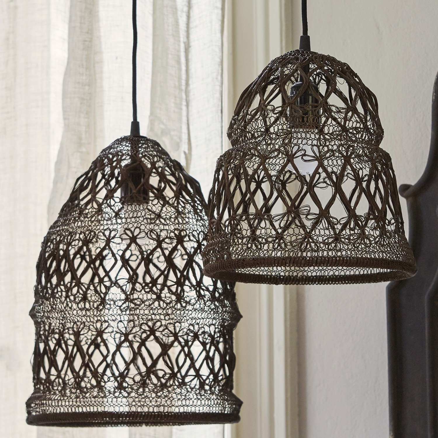 Zwei hängende Lampen aus braunem Rattan mit filigranem Muster, dekorative Innenbeleuchtung