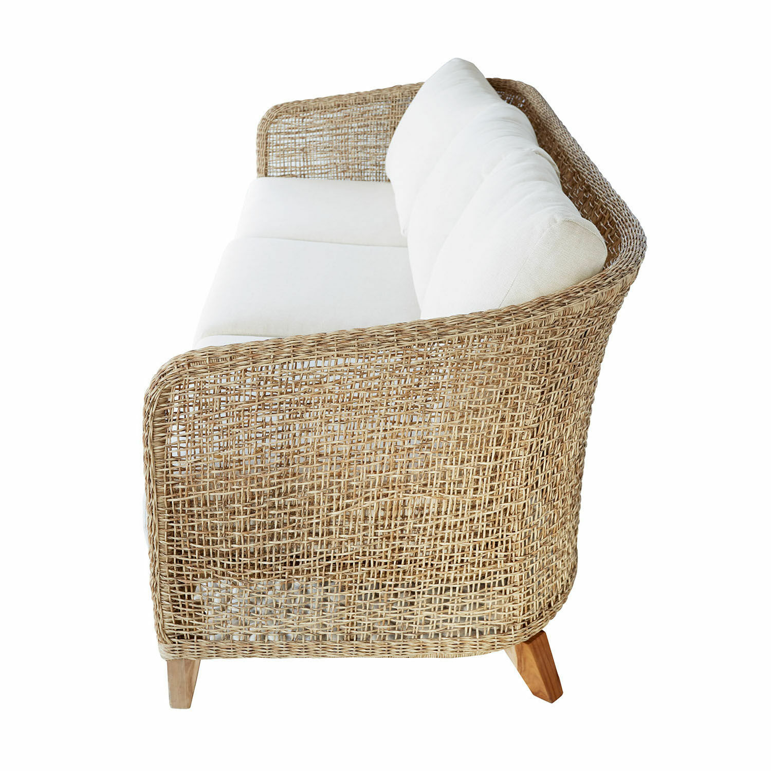 Rattansofa mit weißen Kissen und Holzbeinen, natürlicher Werkstoff und helle Farbe