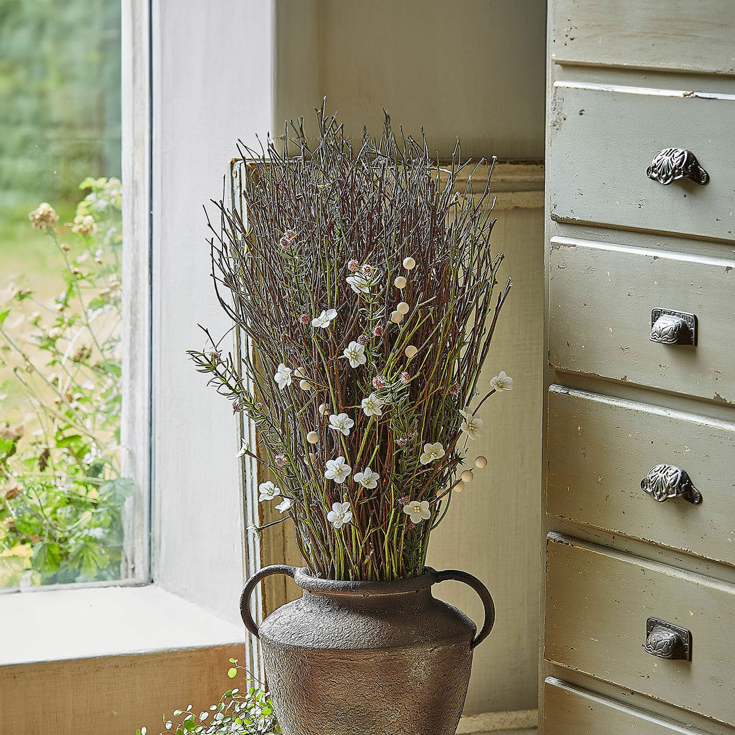 Deko-Blumenstrauß Verilo Dekorativer brauner Metallvase mit Zweigen und weißen Blüten auf Fensterbank