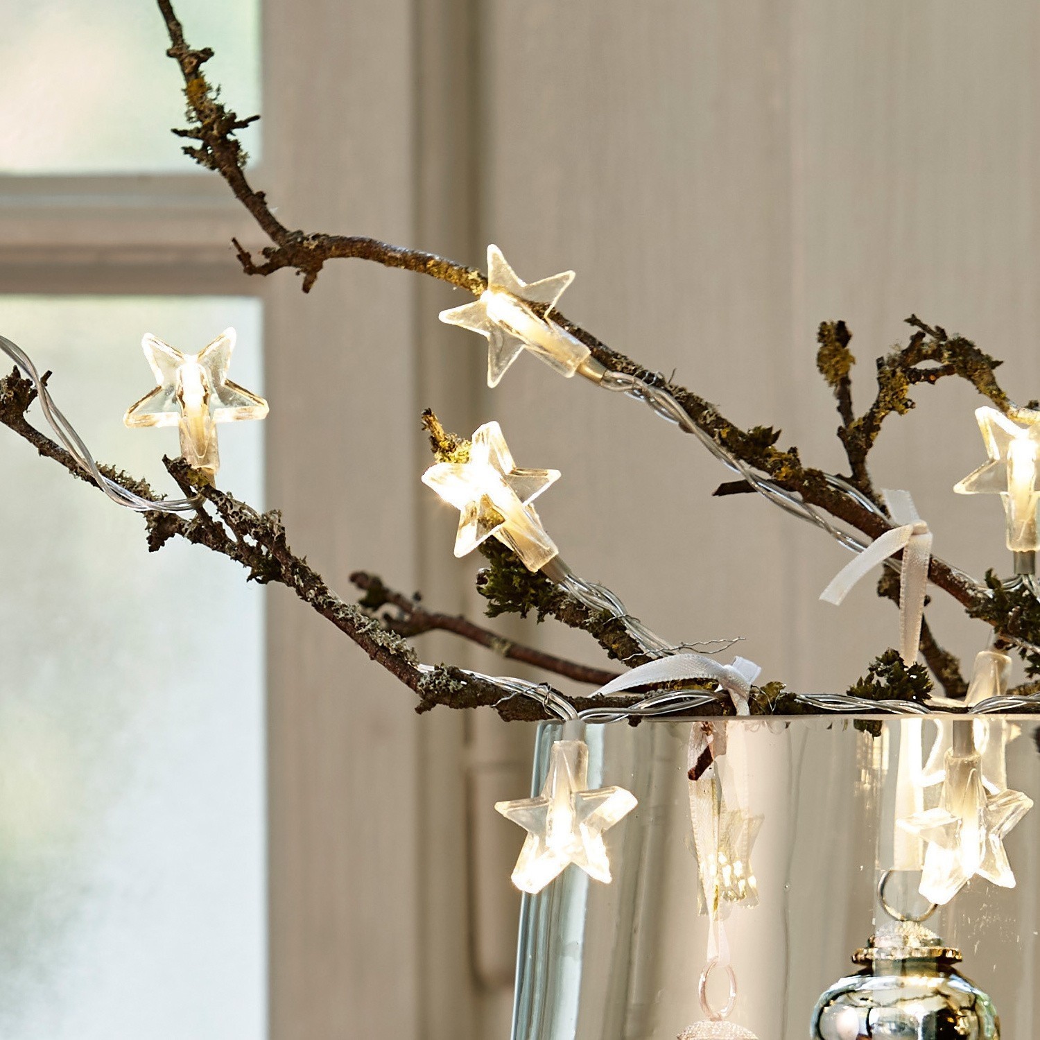 LED-Lichterkette mit sternförmigen Lampen an Zweigen in Glasvase, weiße Weihnachtsdekoration