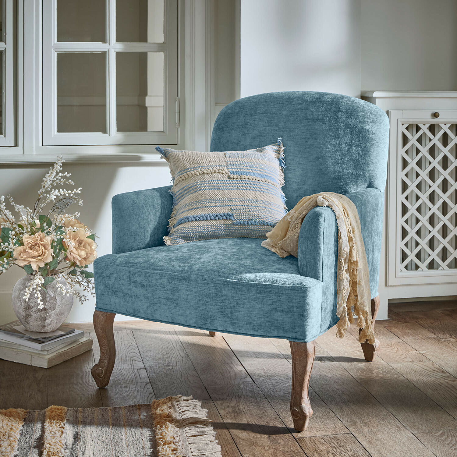Sessel Clairmont Bleu Blauer Polstersessel mit Holzbeinen und dekorativem Kissen in gemütlichem Wohnraum