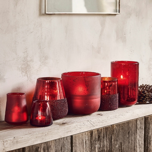 Set aus roten Glaswindlichtern auf Holzregal, dekorative Wohnraumbeleuchtung