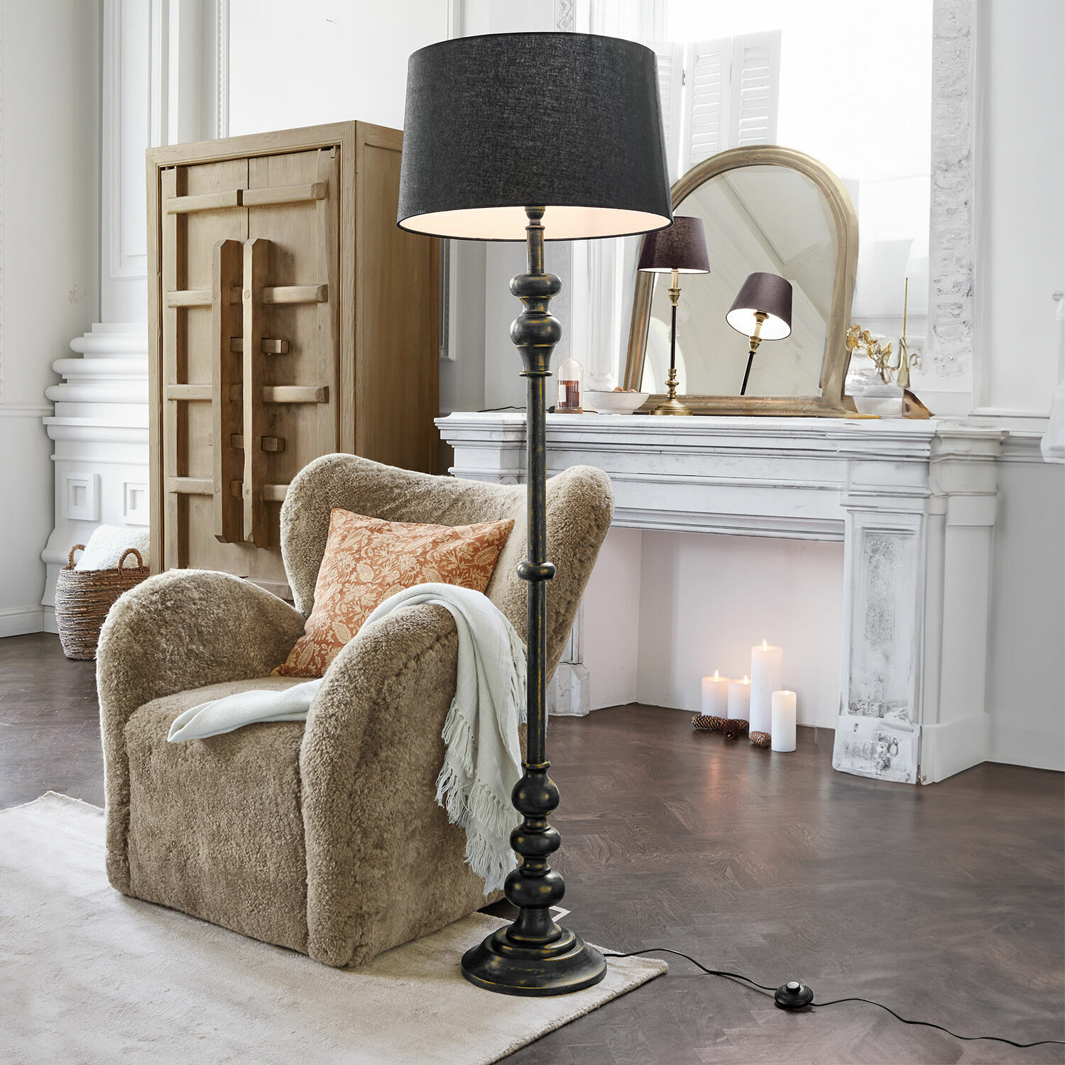 Stehlampe Reville Schwarze Stehlampe mit Lampenschirm im klassischen Wohnzimmer mit beigem Sessel und weißem Kamin