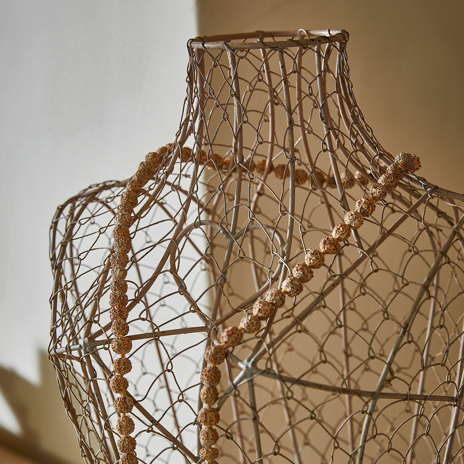 Dekorative Halskette aus braunen Naturperlen auf einem Drahtkleidermannequin