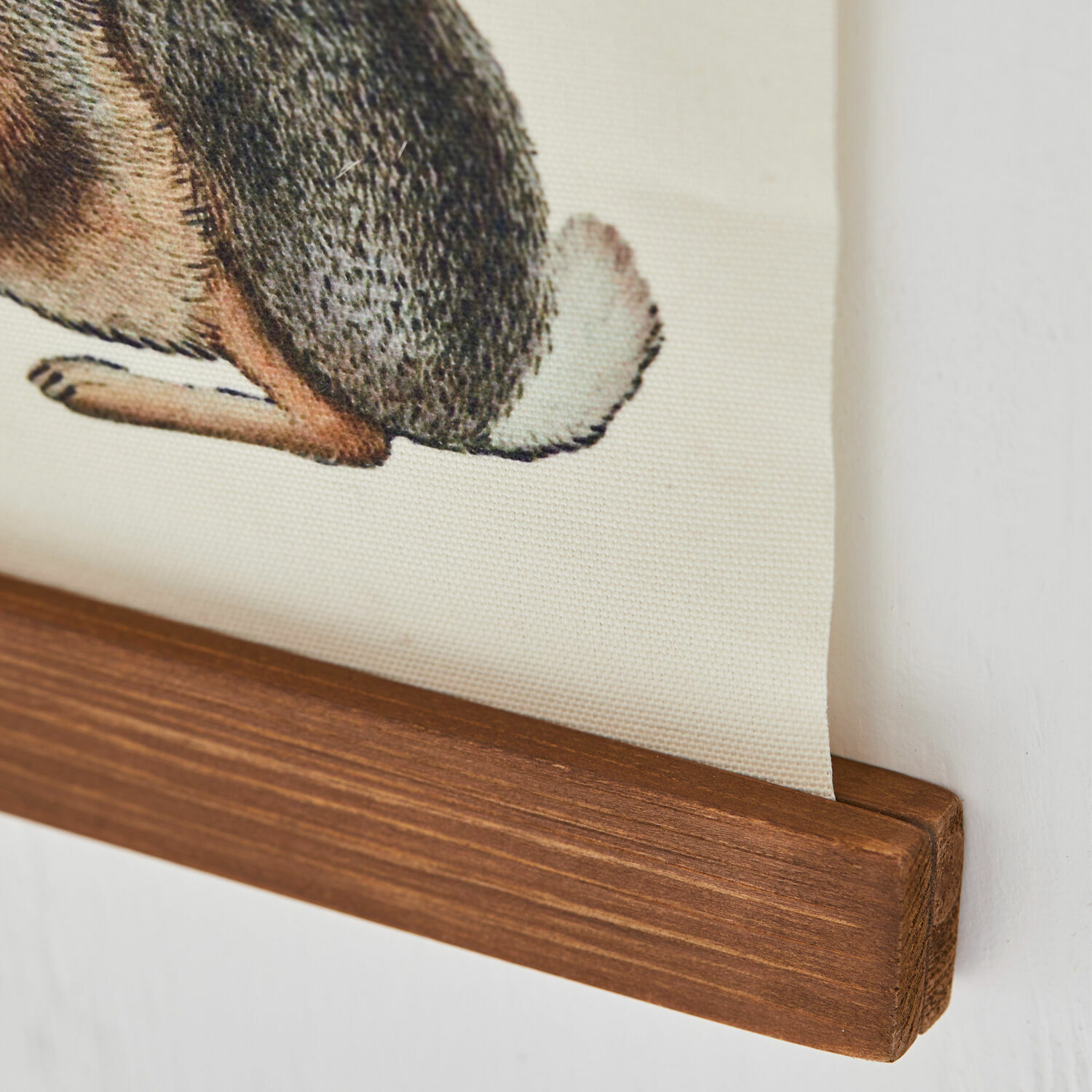 Holzleiste mit beigem Stoff und Tier-Schwanz-Motiv als Wanddekoration