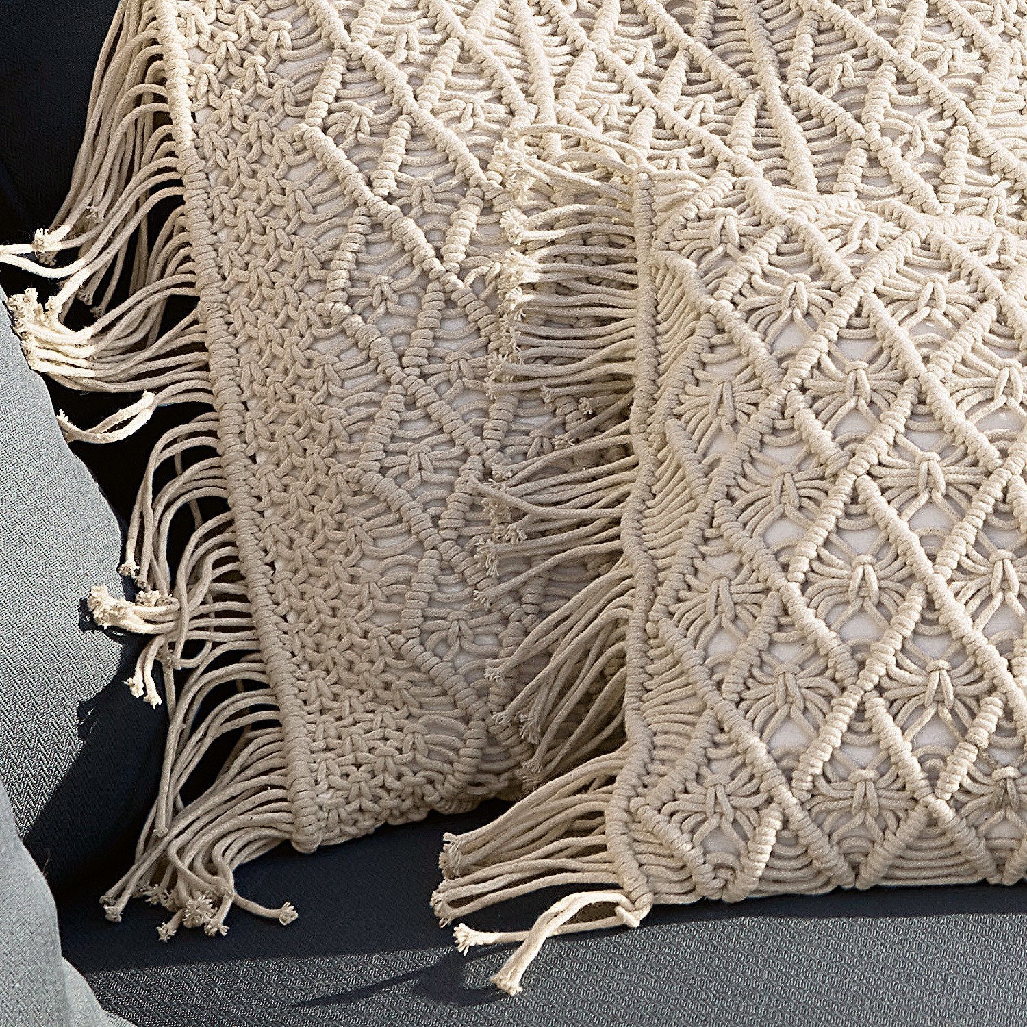 Beige Makramee-Kissen und Decke aus Baumwolle auf dunkelgrauem Sofa, Wohnraumdekoration