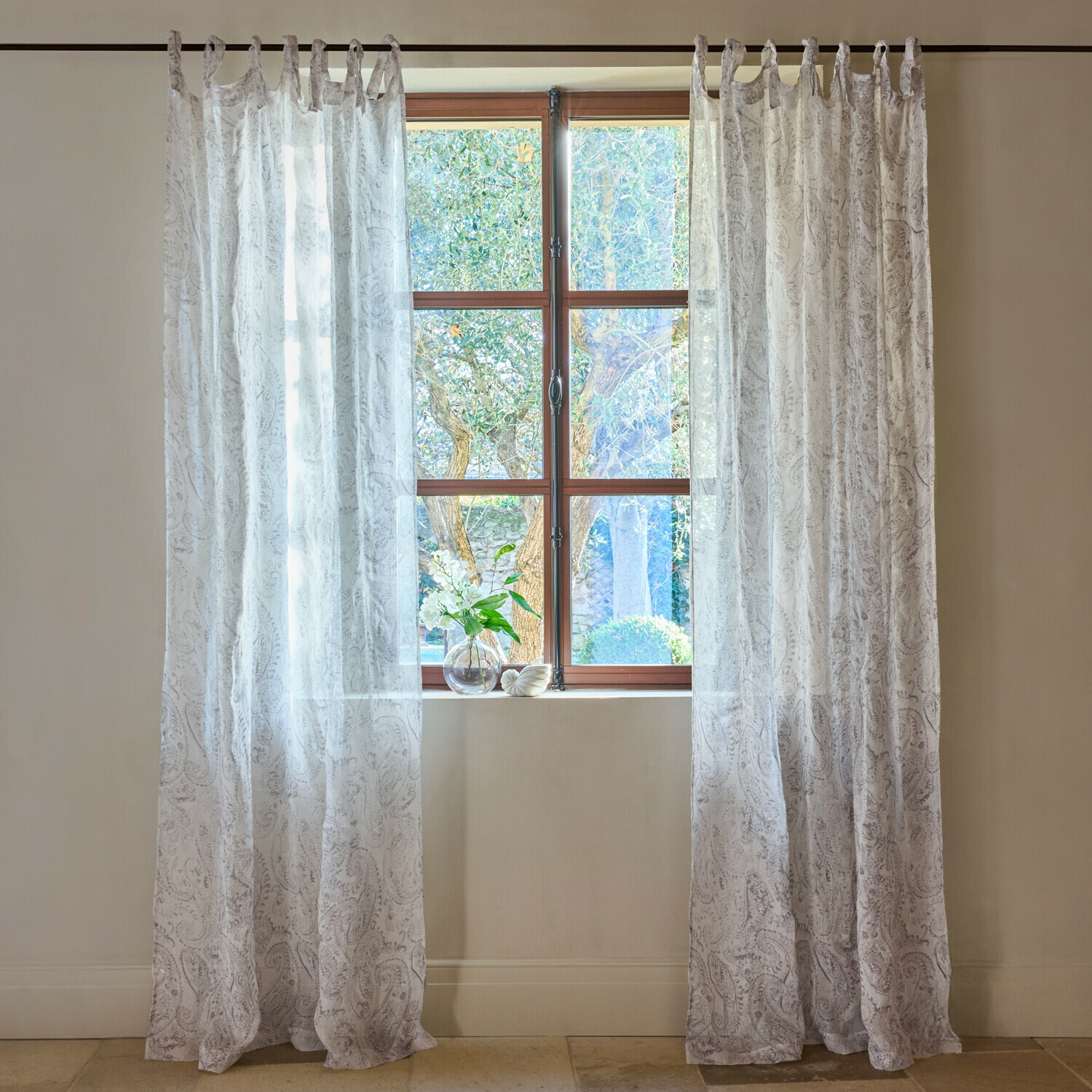 Transparente weiße Vorhänge mit feinem Paisley-Muster am Fenster, helle Wohnraumdekoration