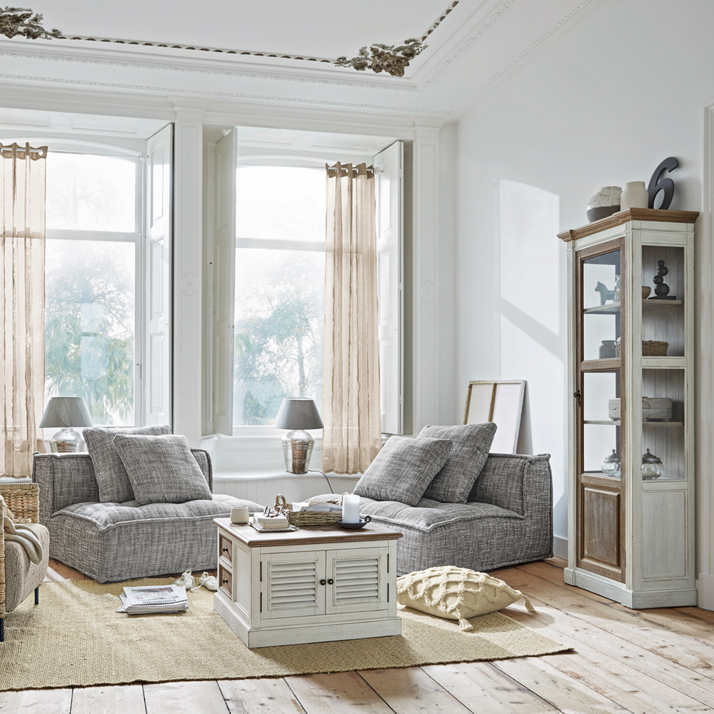 Helles Wohnzimmer mit grauen Sesseln und weißem Holzschrank auf Juteteppich, moderner skandinavischer Stil