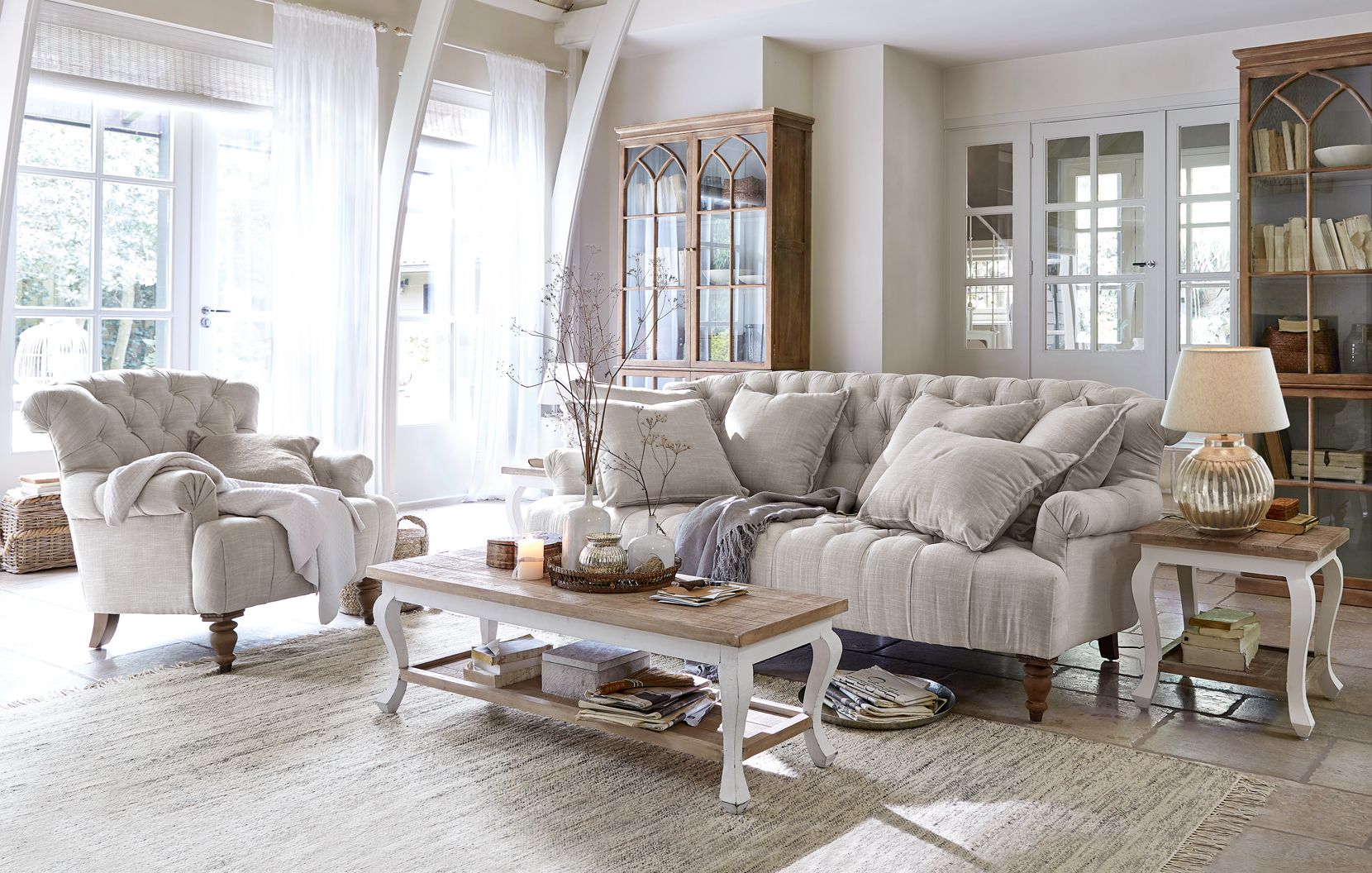 Gemütliches Landhaus-Wohnzimmer mit beigem Stoffsofa, Sessel und hellen Holzmöbeln