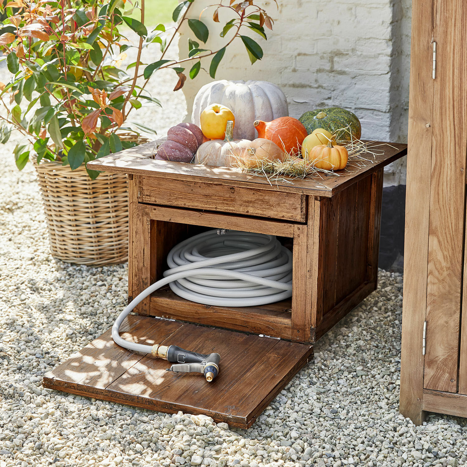 Gartenschlauchtopf Fontabre Holz-Gartenschrank mit grauem Gartenschlauch und dekorativen Kürbissen oben