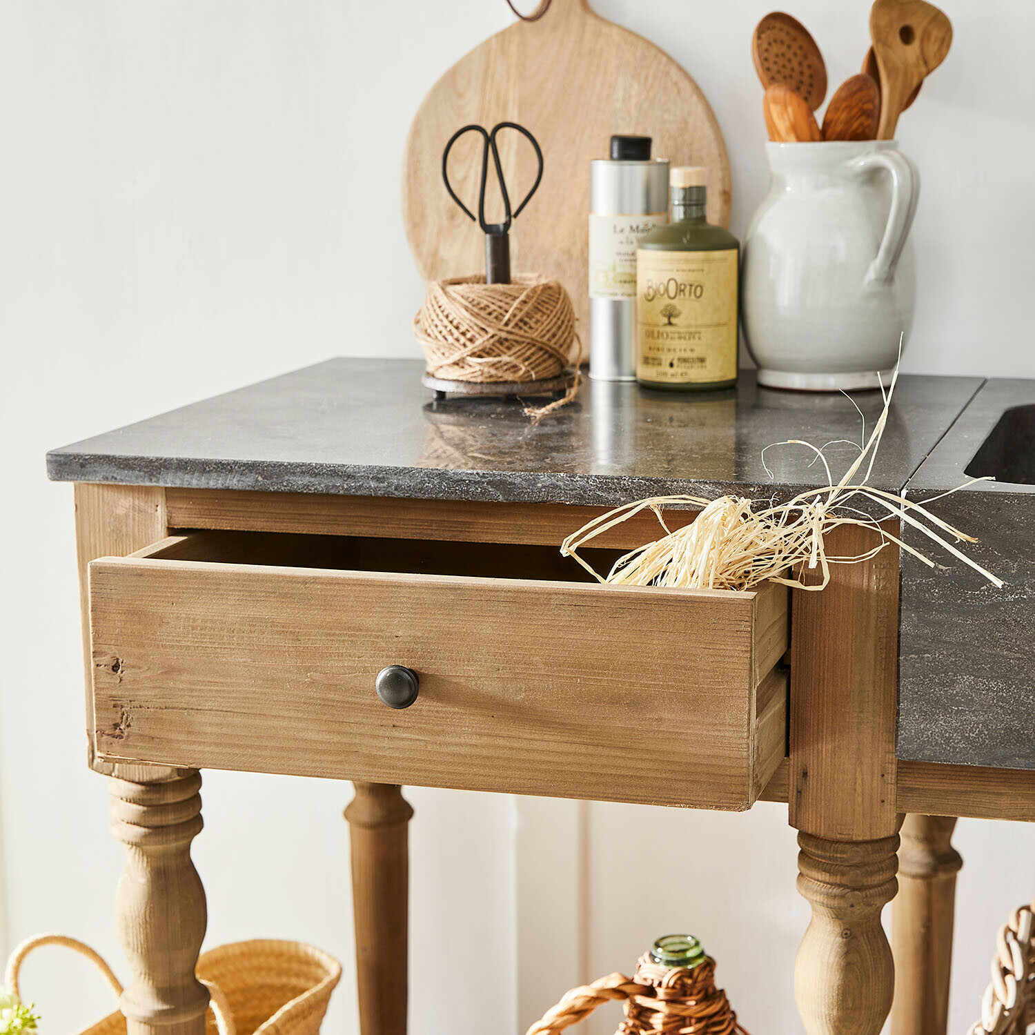 Küchentisch aus Holz mit Schublade und Steinplatte, Küchenutensilien auf der Arbeitsfläche