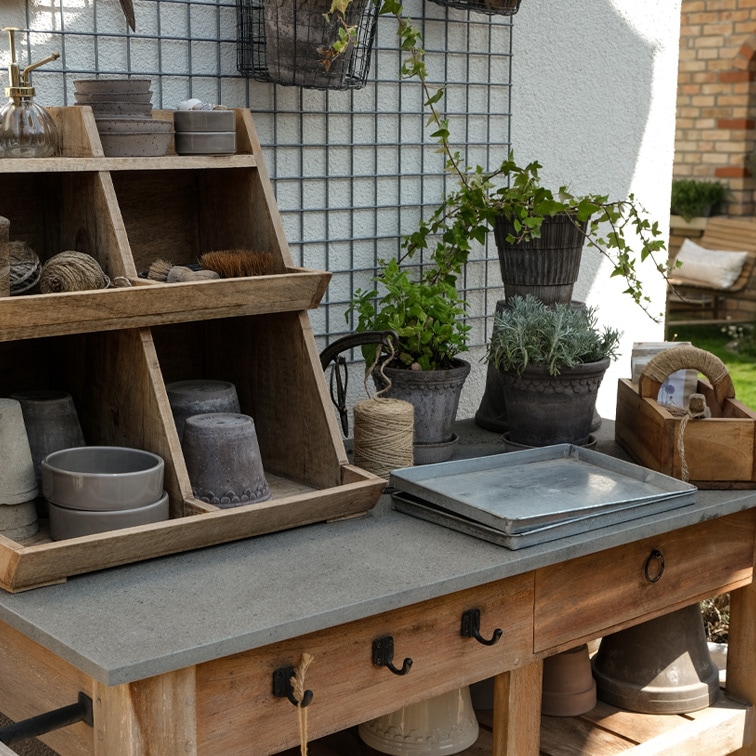 Gartentisch aus Holz mit Betonplatte, Pflanztöpfen, Gartengeräten und Schnüren