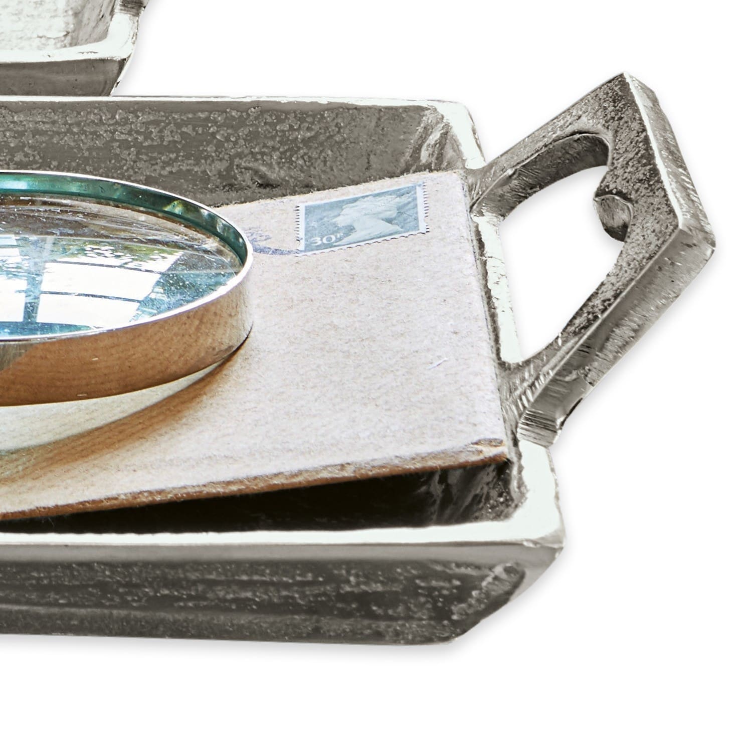 Dekoratives silberfarbenes Metalltablett mit Griff und Lupe auf einem Umschlag