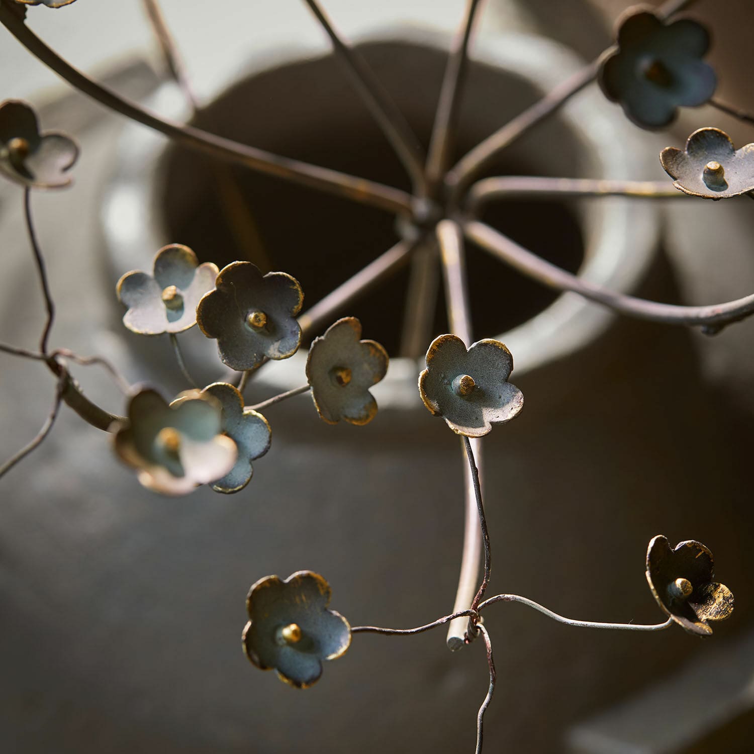 Dekorative Metallblume in Grau mit goldenen Akzenten, stilvolles Wohnaccessoire