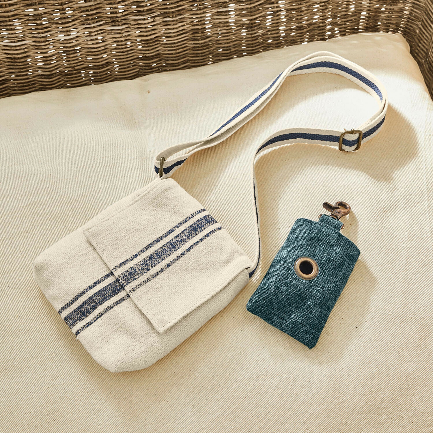 Beige Baumwolltasche mit blauen Streifen und grüne Schlüsselhülle mit Metallkarabiner