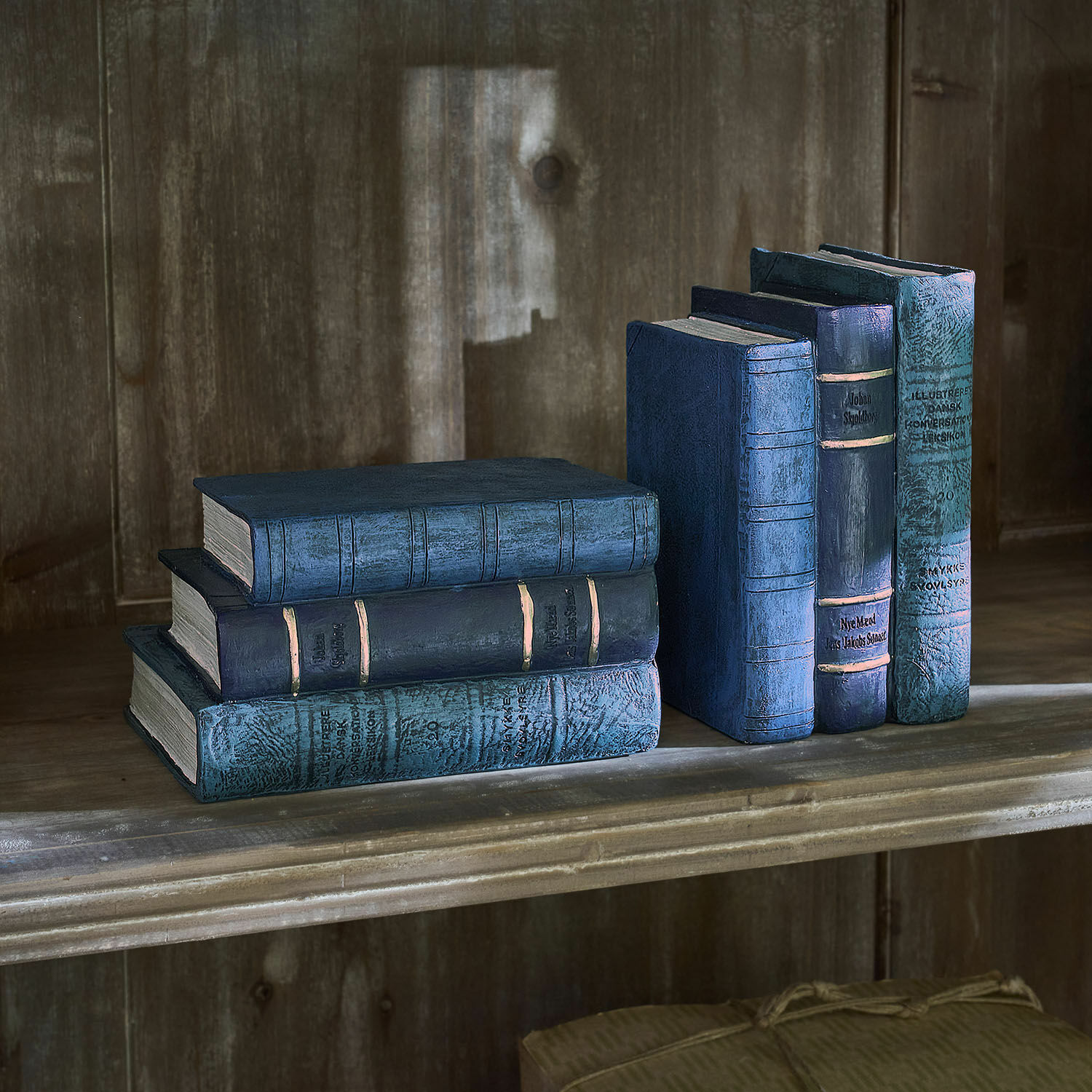 Sechsteiliges Set dekorativer blauer Bücher auf Holzregal für Wohnraumgestaltung