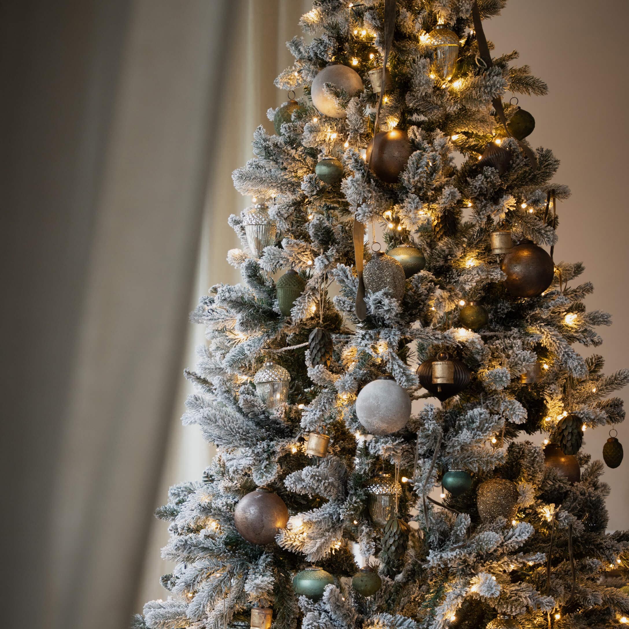 Künstlicher Weihnachtsbaum mit Schneeeffekt und gold-grünen Kugeln, LED-Lichterkette für festliche Deko