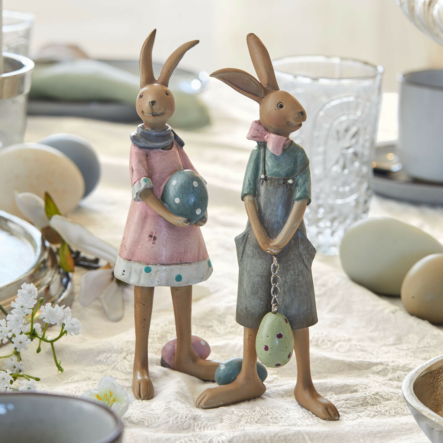 Hase 2er Set Sivalex Zwei dekorative Hasenfiguren aus Metall in Pastellfarben mit Ostereiern auf einem Tisch