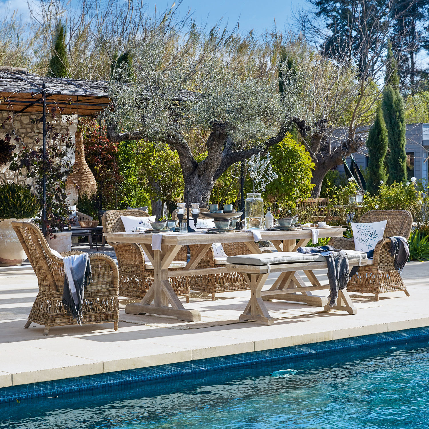 Gartenmöbel-Set aus Holz und Rattan in Naturtönen am Pool auf der Terrasse