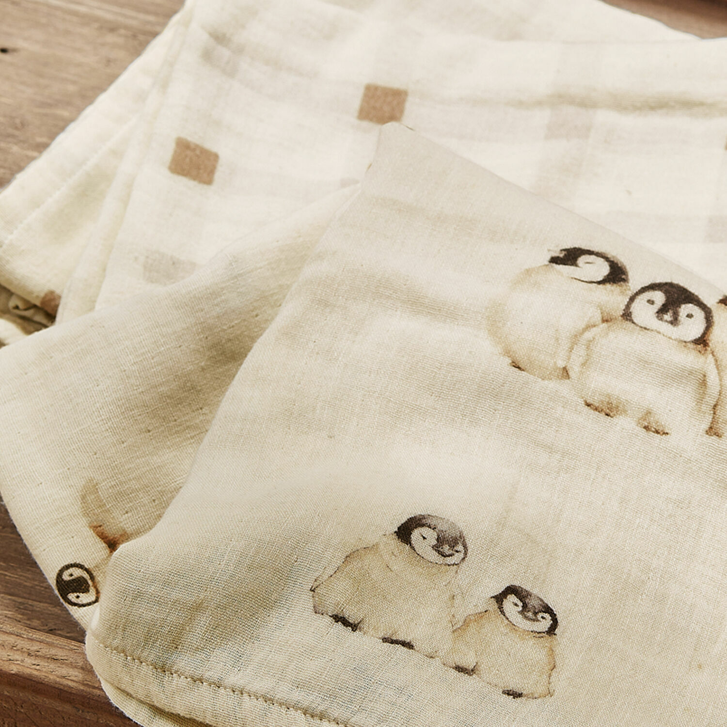 Weicher Baumwollstoff in Creme mit Pinguin-Motiv und dezentem Karomuster in Beige