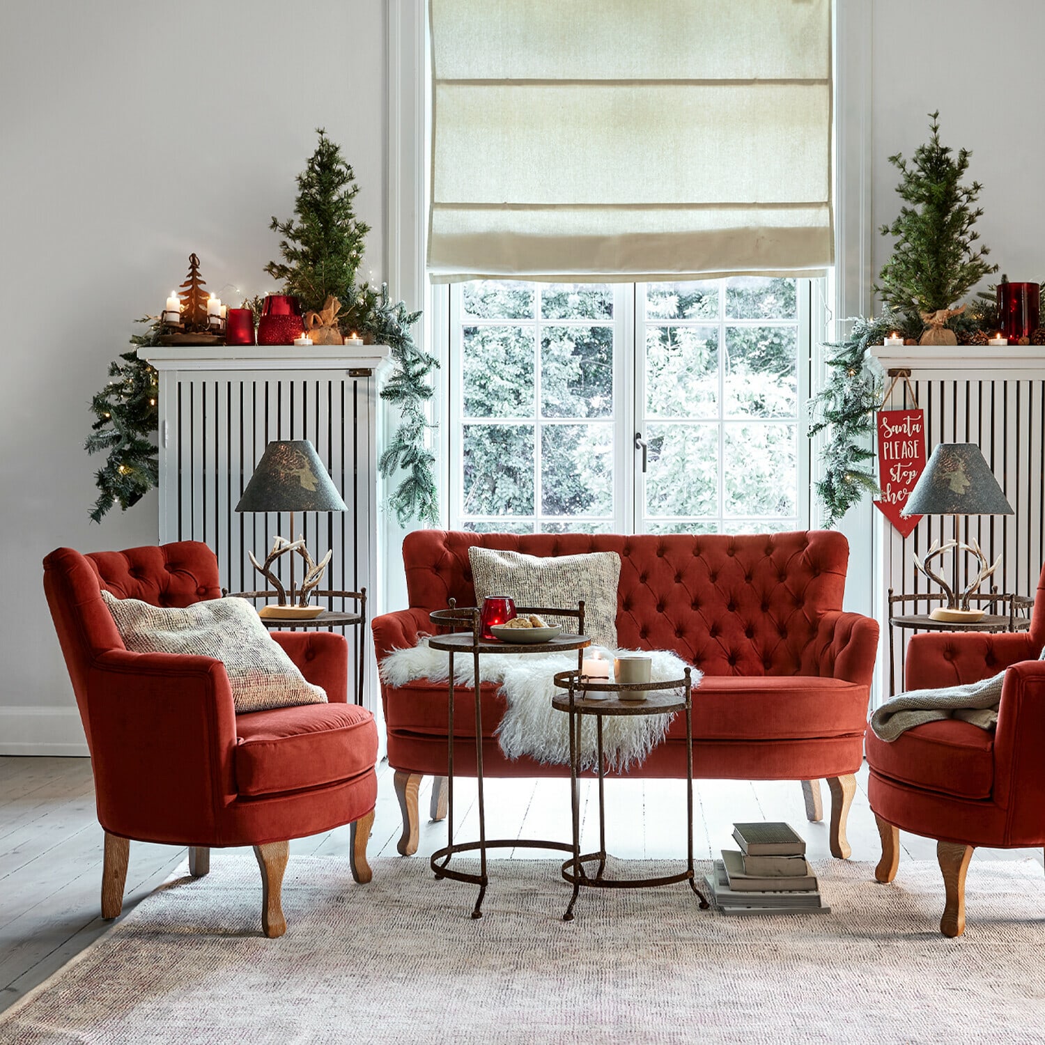 Rotes Samt-Sitzmöbel-Set mit Kissen und Metalltischen in gemütlichem Wohnzimmer mit Weihnachtsdeko