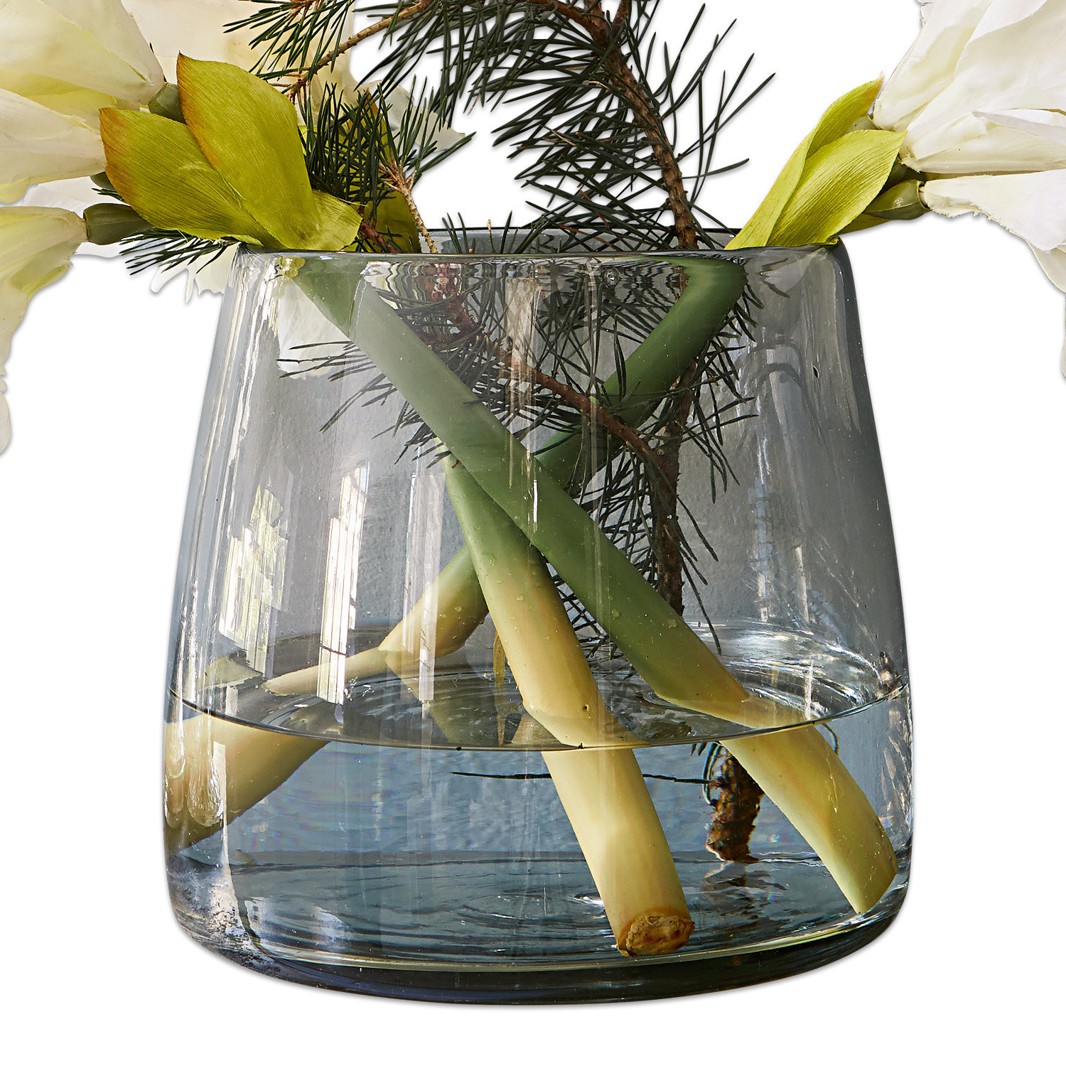 Vase Inga Transparenter Glasvase mit Wasser, grünen Stielen und weißen dekorativen Blumen
