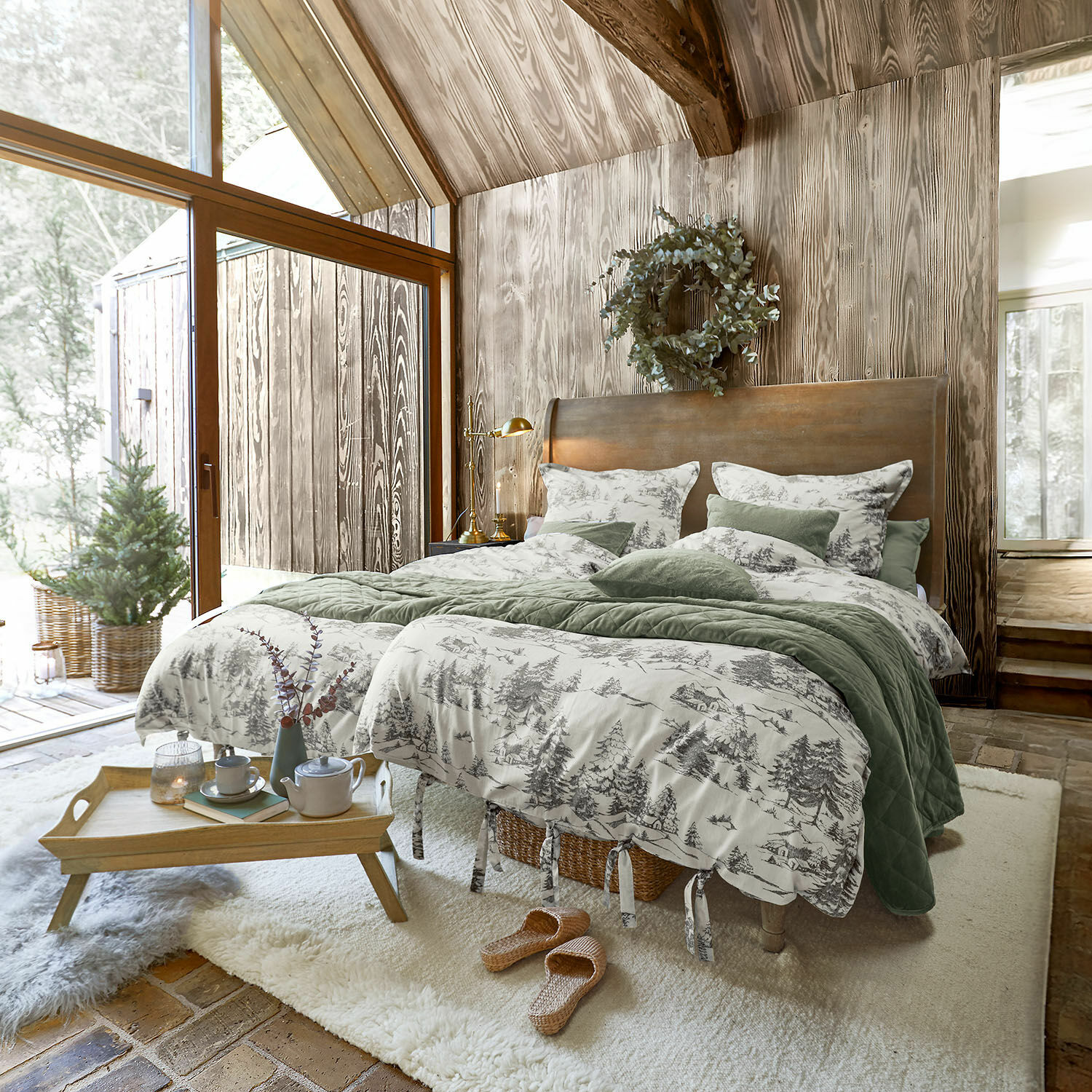 Bettwäsche Héroux Gemütliches Schlafzimmer mit Holzwand und Bett mit grün-grauer Waldmuster-Bettwäsche