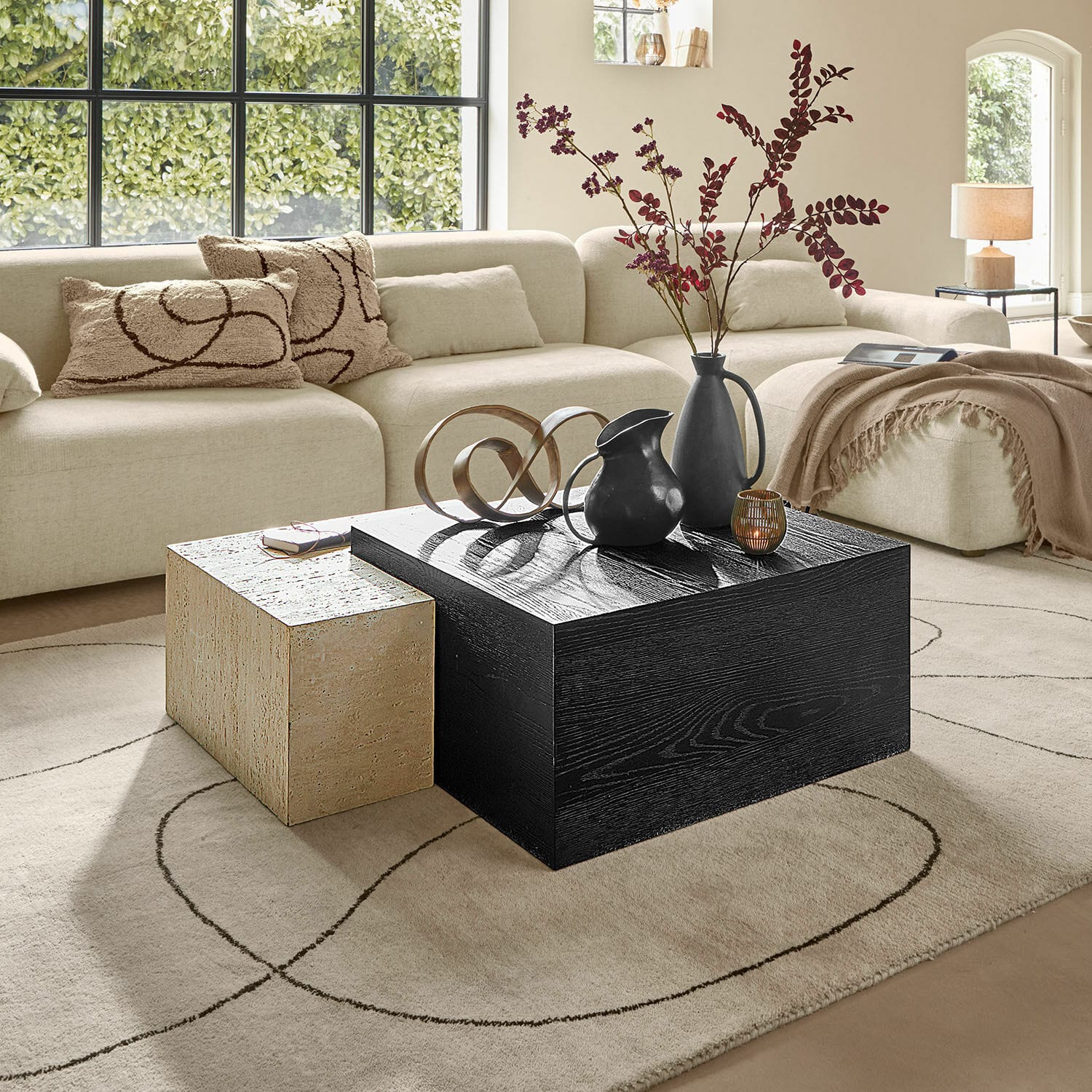 Couchtisch 2er Set Caleneuve Moderner Wohnraum mit beigem Sofa und zwei Couchtischen aus Holz und Stein, Dekorationen darauf
