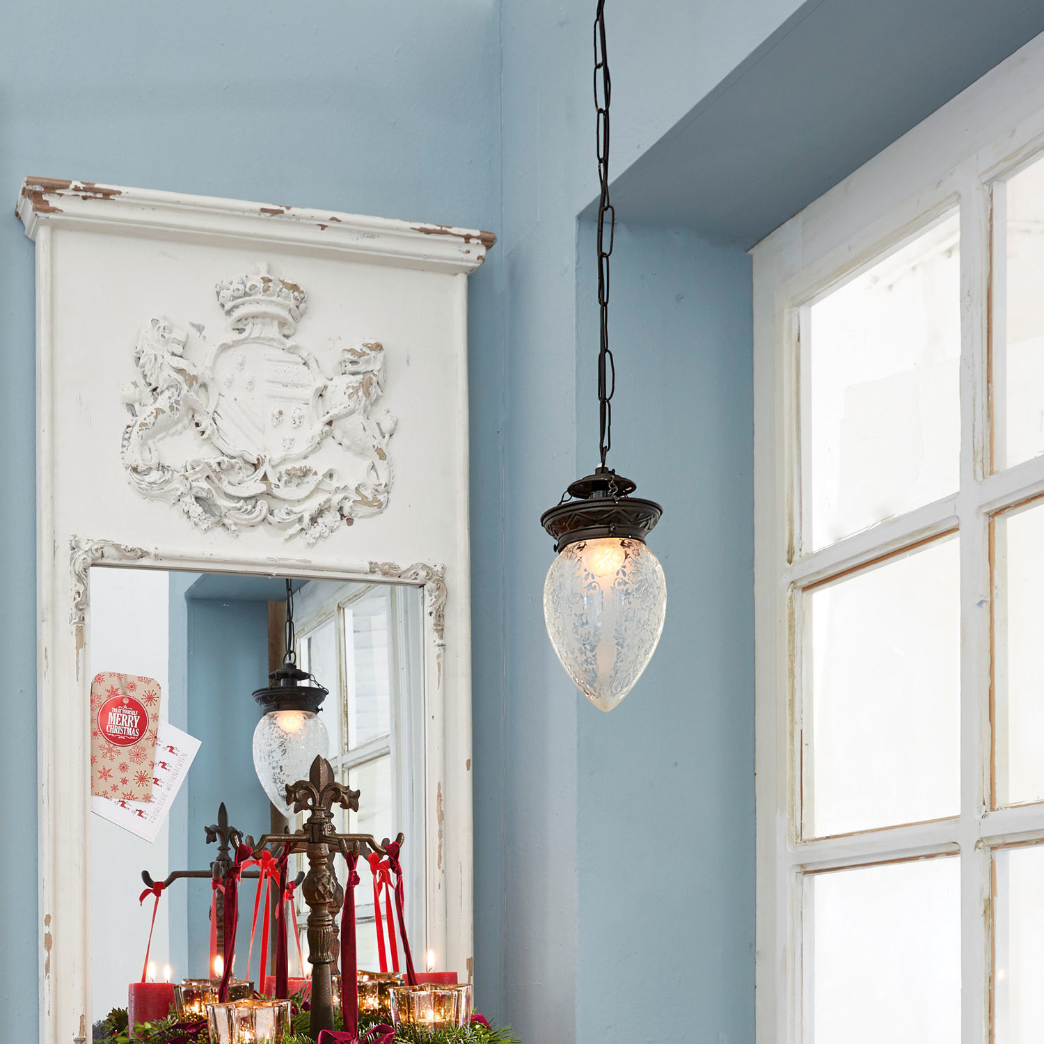 Hängelampe aus mattiertem Glas und Metall im Vintage-Stil vor blauem Wandhintergrund und Spiegel