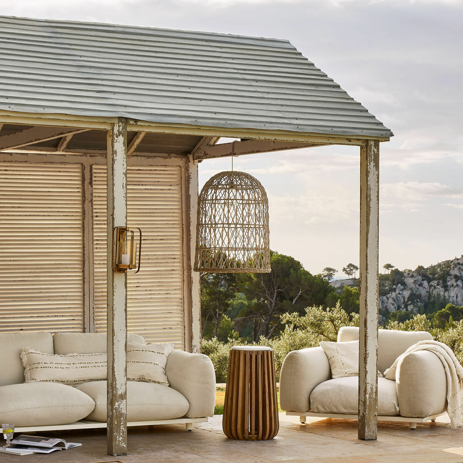 Gemütliche Outdoor-Möbel mit beigem Stoffbezug und Holz-Beistelltisch auf Terrasse mit Naturblick