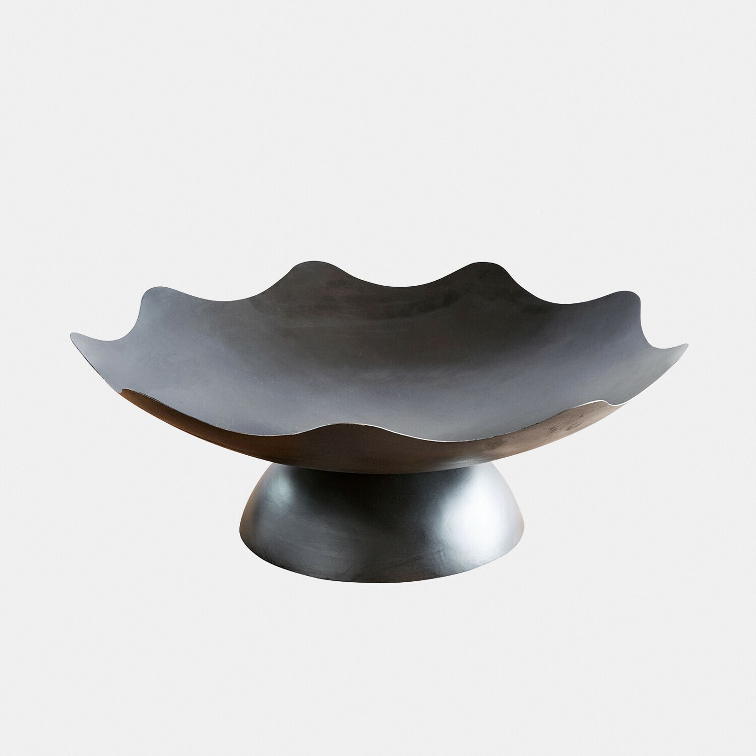 Dekorative schwarze Metallschale mit wellenförmigem Rand auf runder Basis, modernes Design