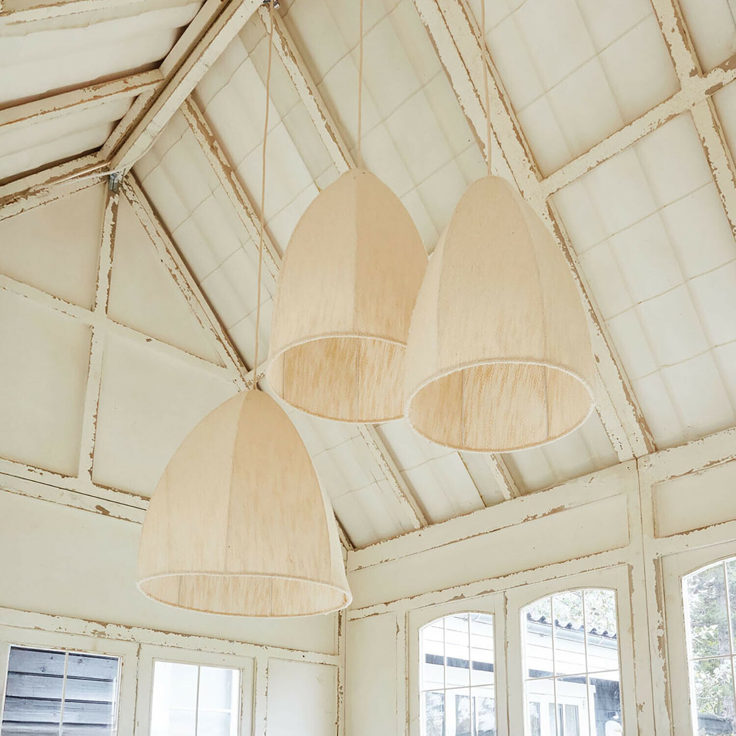 Drei hängende Lampen aus Naturmaterial in Beige in einem hellen, rustikalen Raum