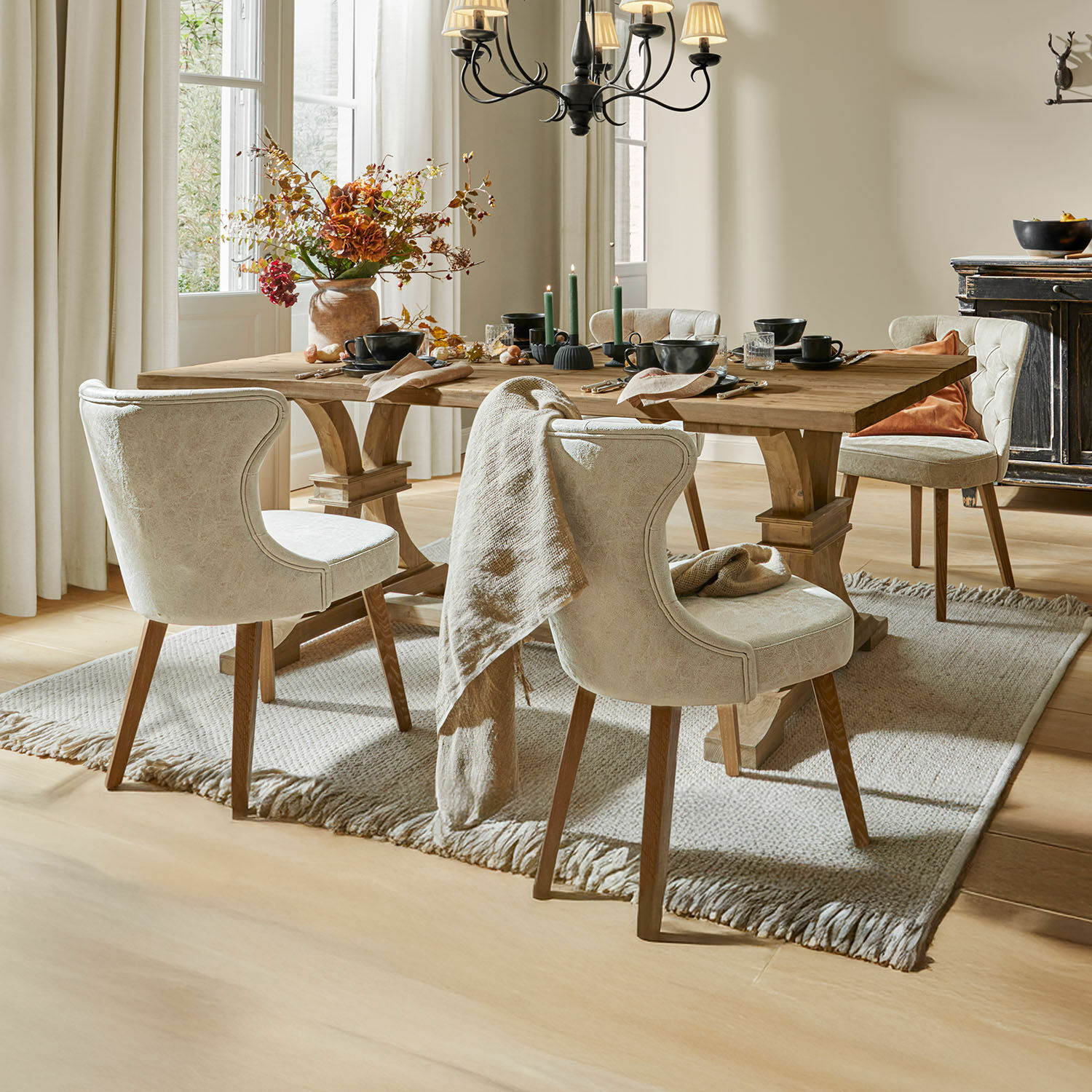 Helle beige Polsterstühle mit Holzbeinen an einem Holztisch im Esszimmer