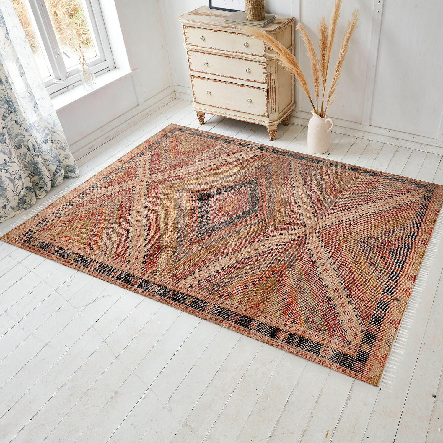 In- & Outdoor-Teppich Mildura Teppich mit geometrischem Muster in warmen Rot- und Beigetönen auf hellem Holzboden