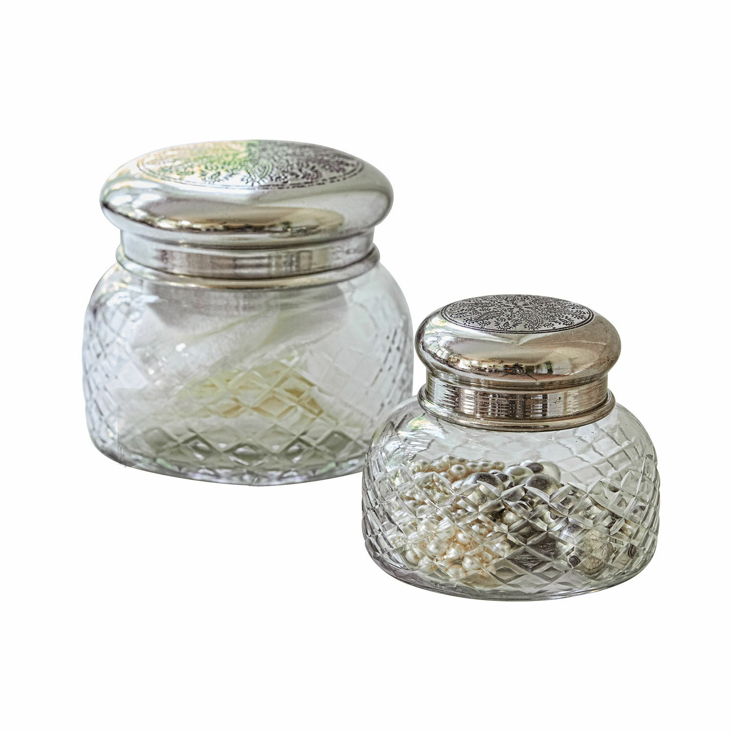 Zwei Glasbehälter mit silbernen Metalldeckeln, ideal zur Aufbewahrung von Schmuck.