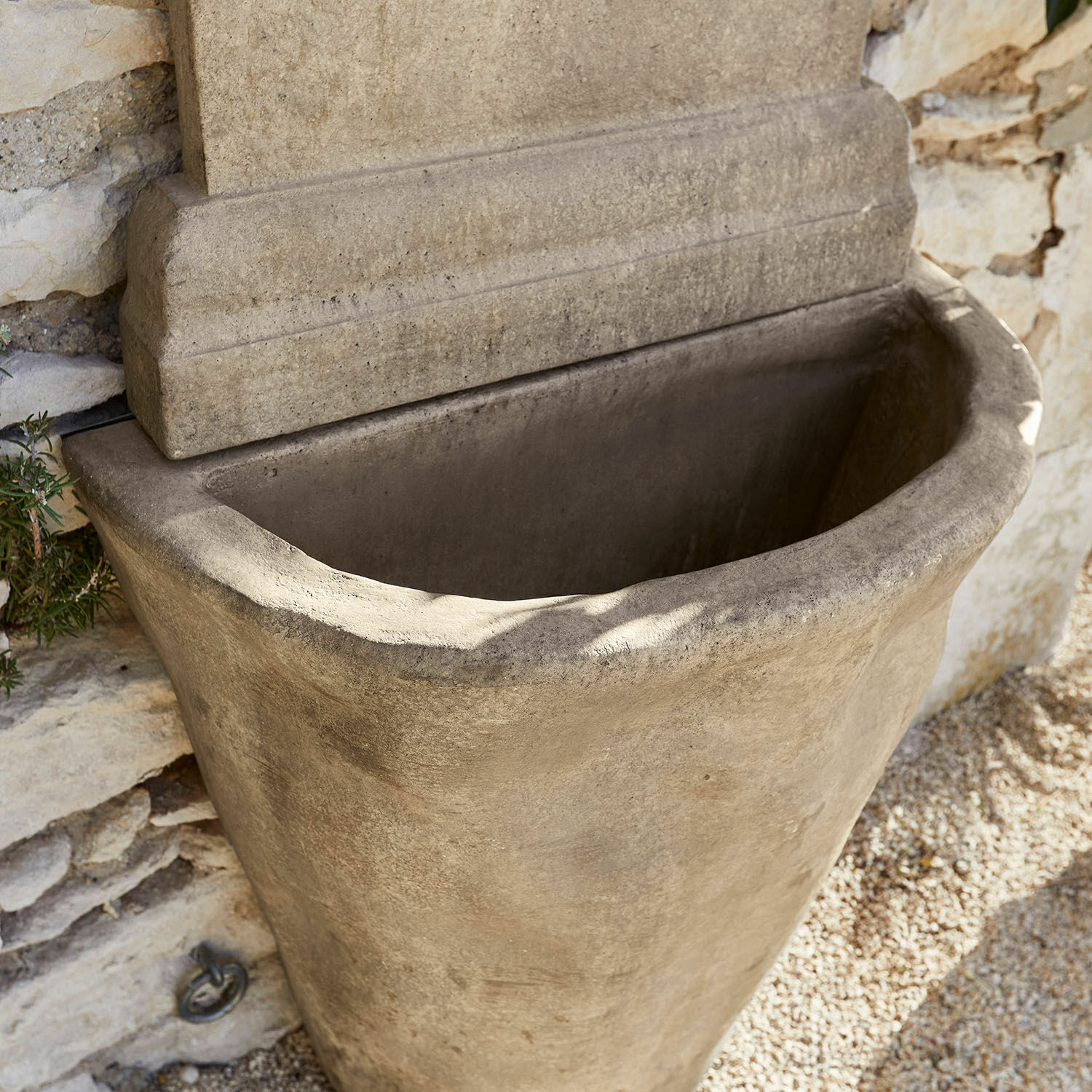 Großer grauer Betontopf an Steinmauer, dekorative Gartendeko für Außenbereiche